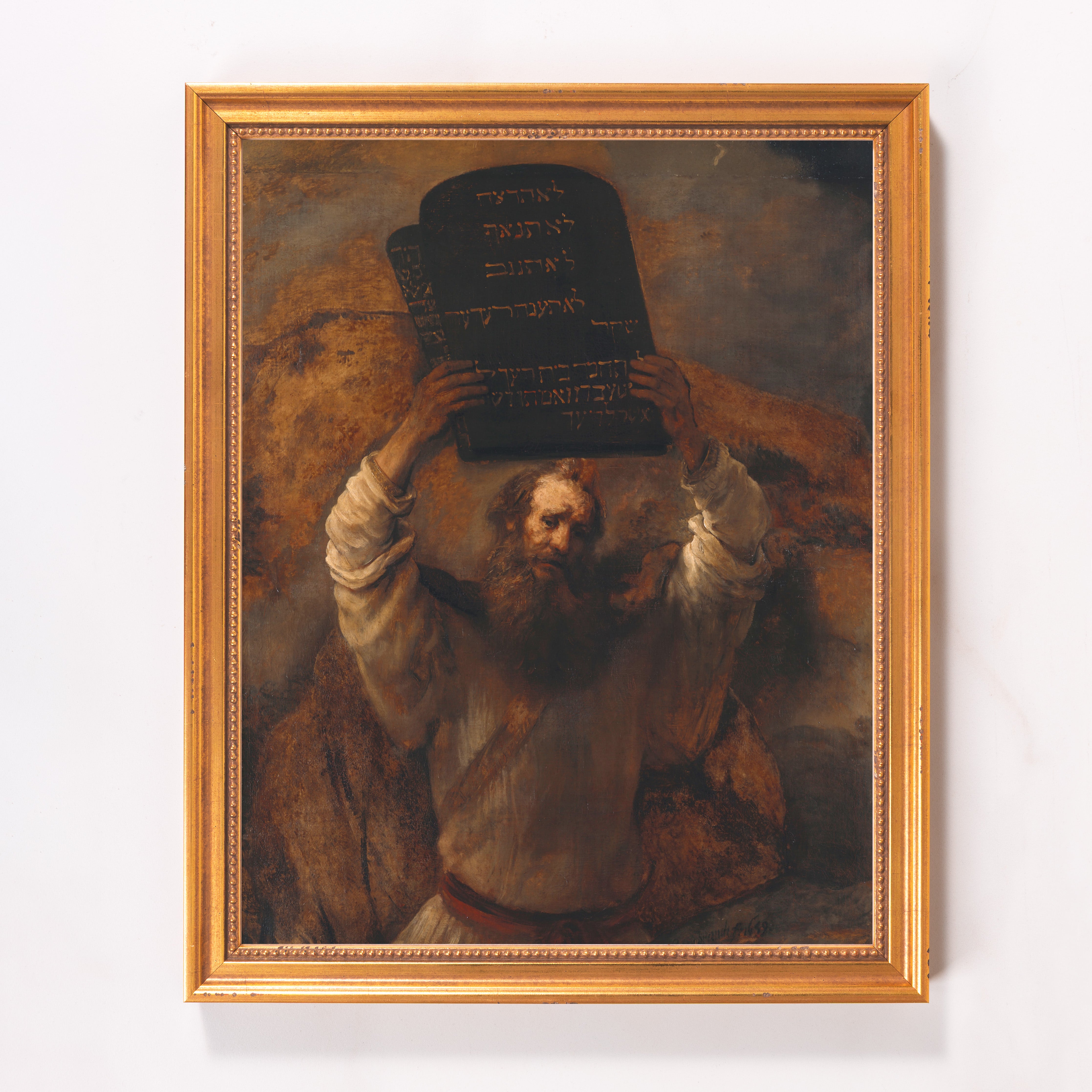 Framed Moses, painting of man holding stone tablets, brown, gold frame.