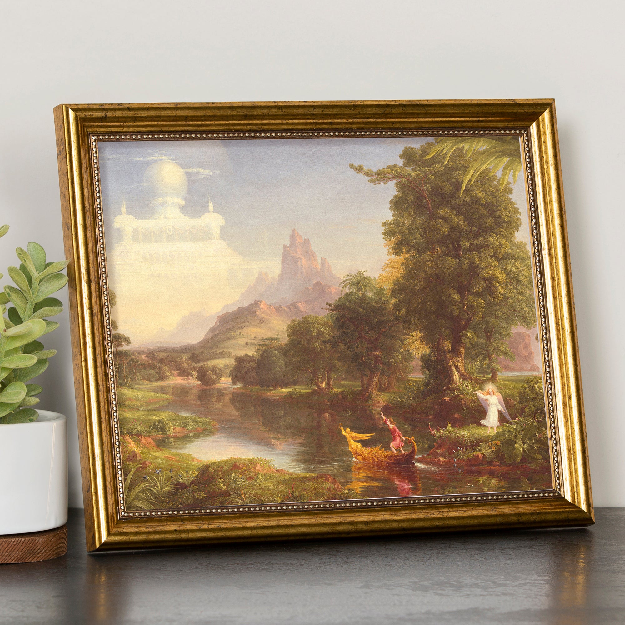 Framed art print of classical painting in a gold frame depicting a landscape with figures.