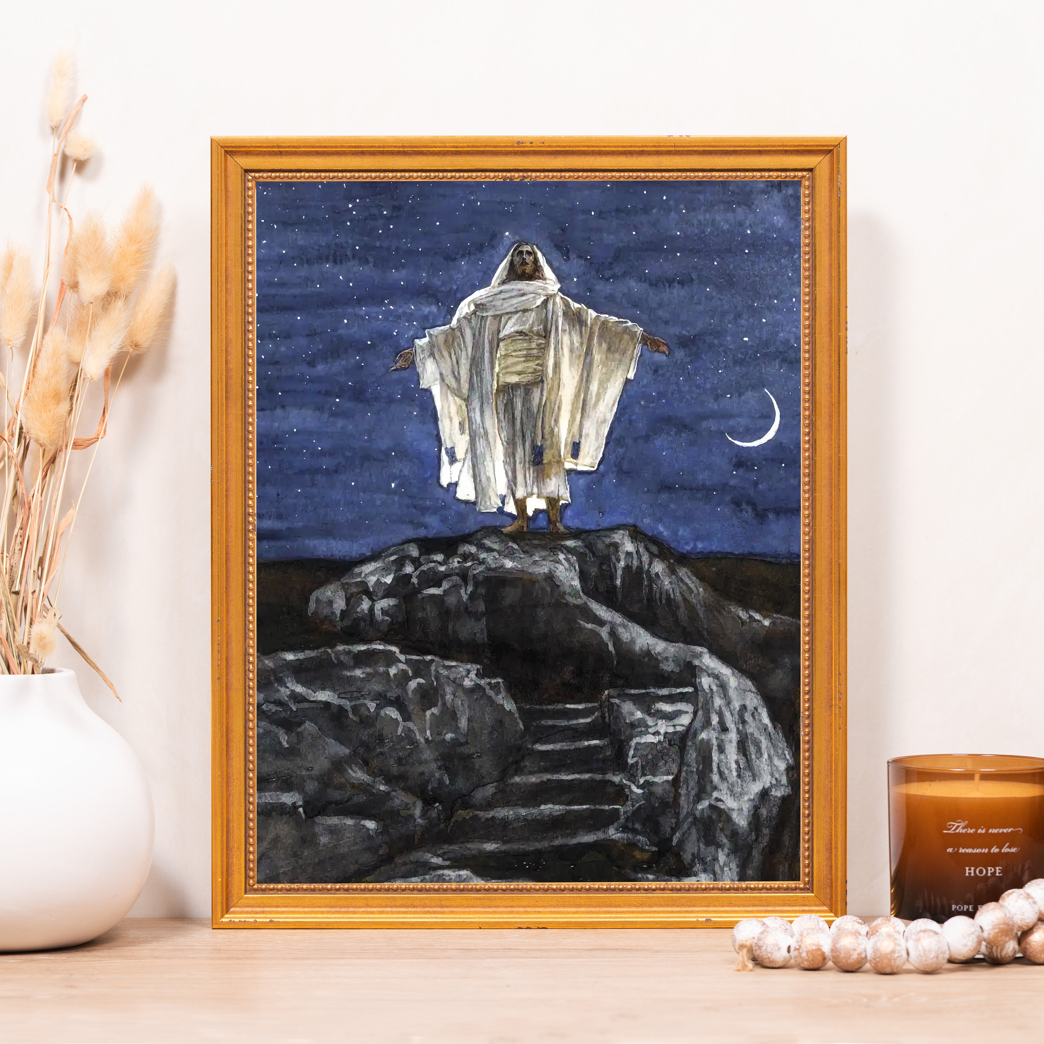 Framed Print of Jesus Christ on mountain, against starry blue sky with moon; gold frame.