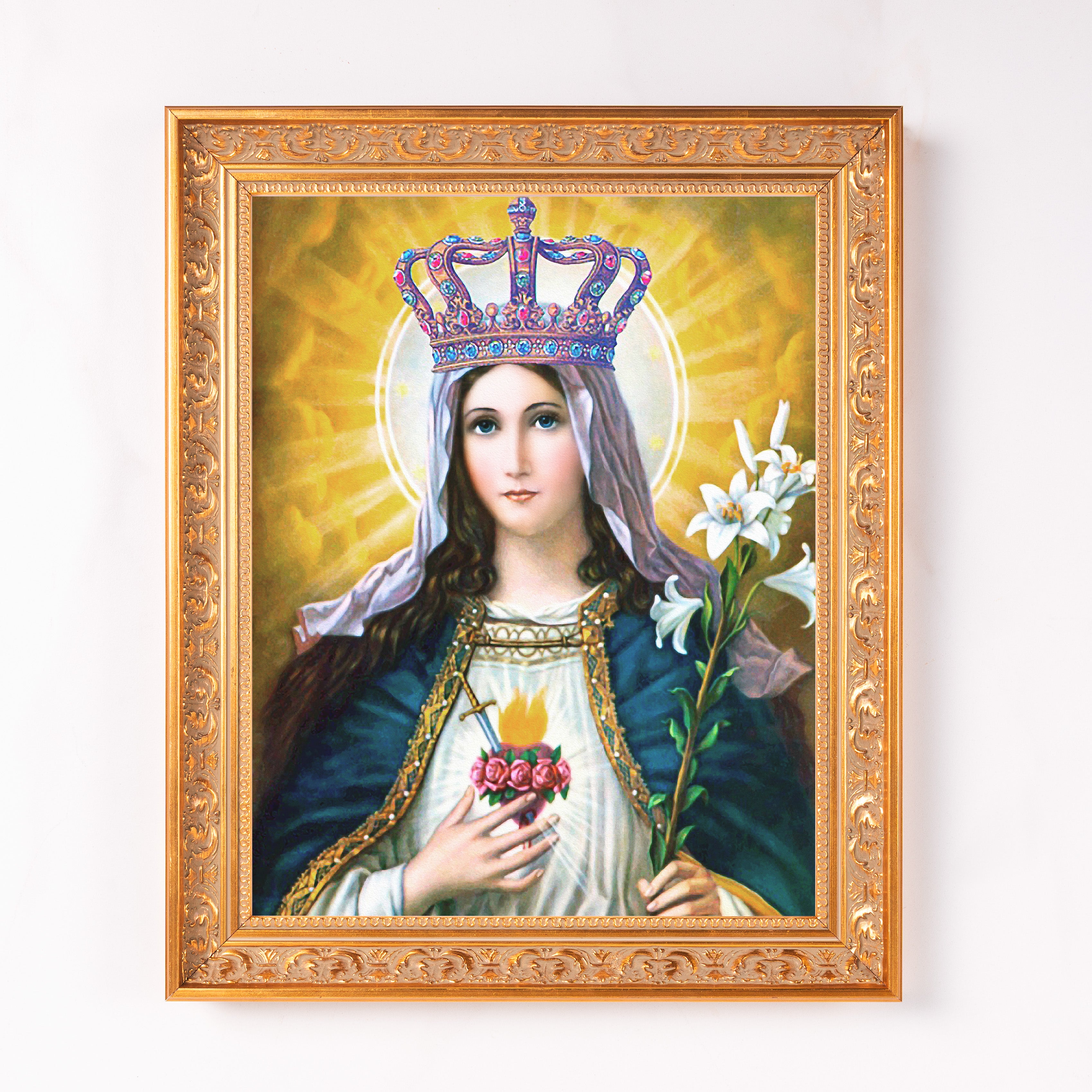 Framed Mary art print for religious display. Gold ornate frame borders a painting of Mary with blue cloak, crown, and white lilies.