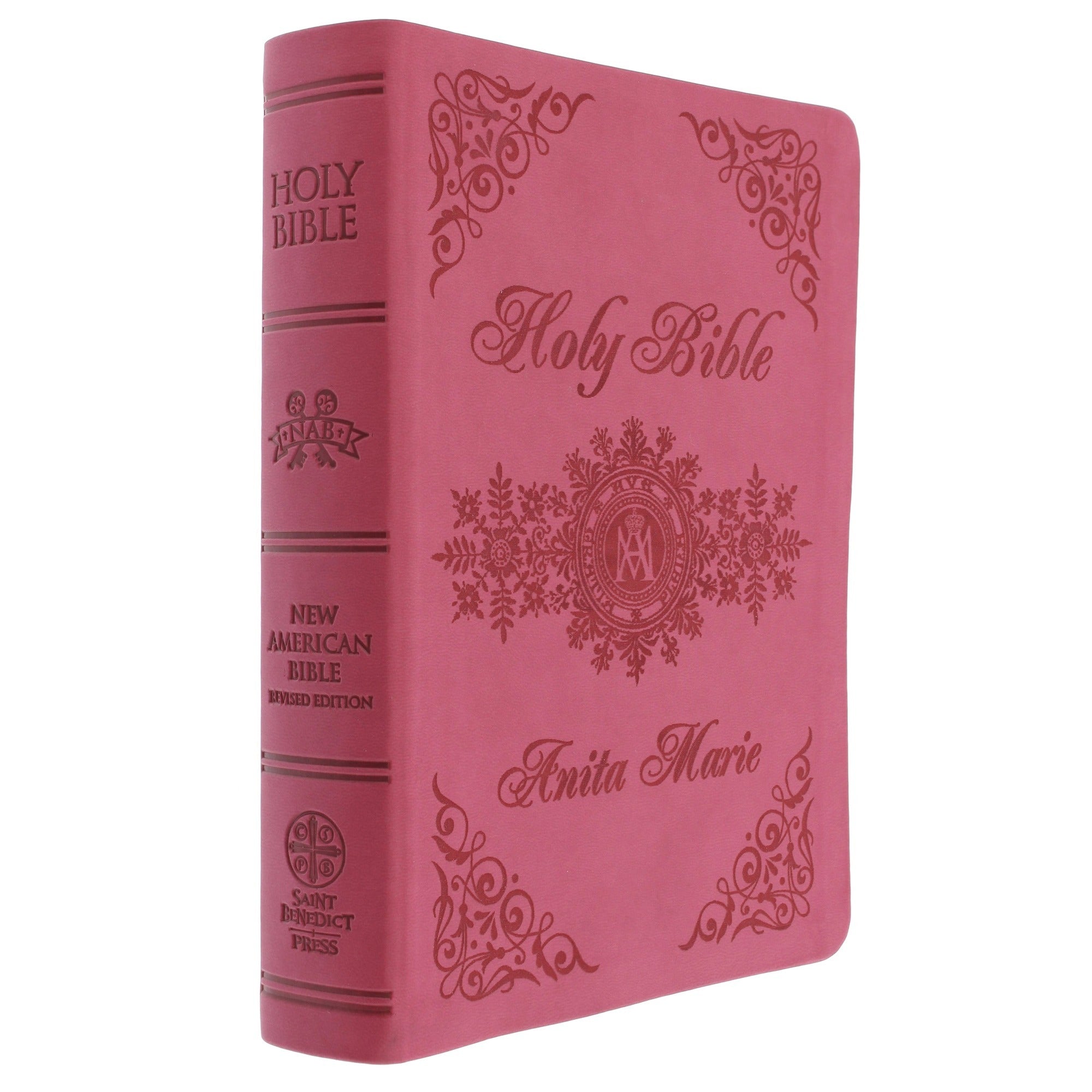 Holy Bible, pink imitation leather cover with decorative embossed designs, and personalized text "Anita Marie.".