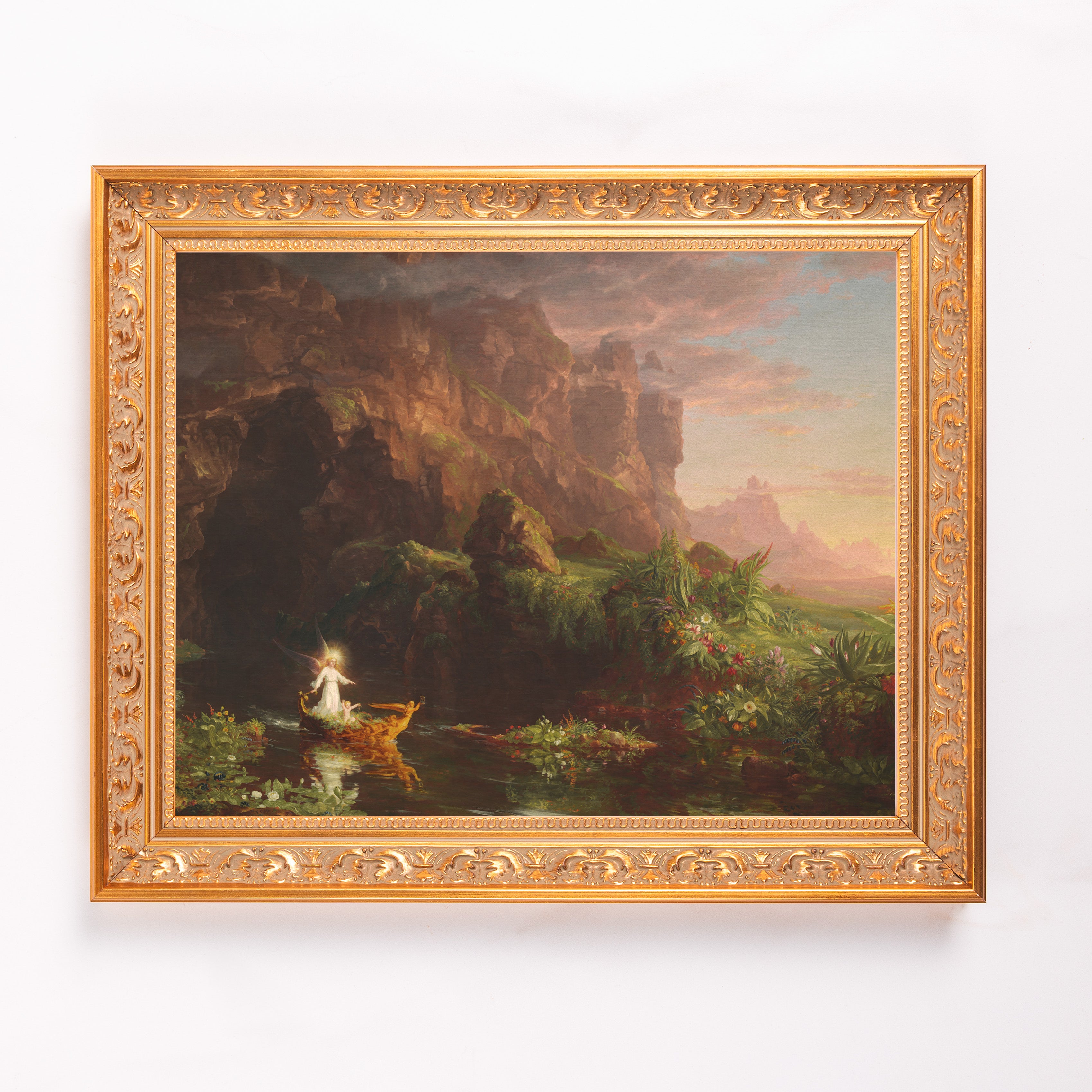 Framed landscape painting with an angel in a boat on a river with a gold ornate frame.
