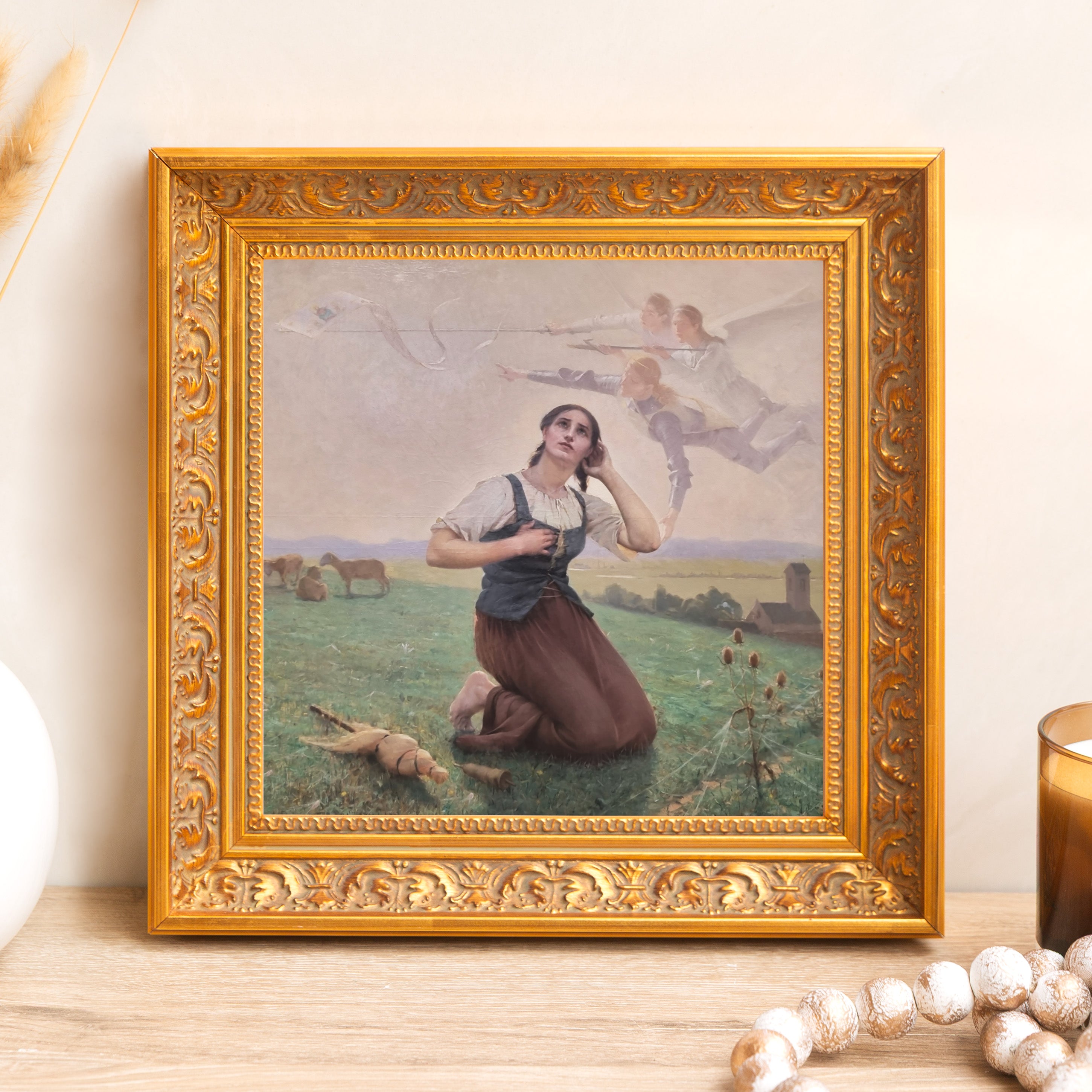 Framed "Joan of Arc" print. Ornate gold frame surrounds a painting of Joan of Arc on bended knee, visited by angels.