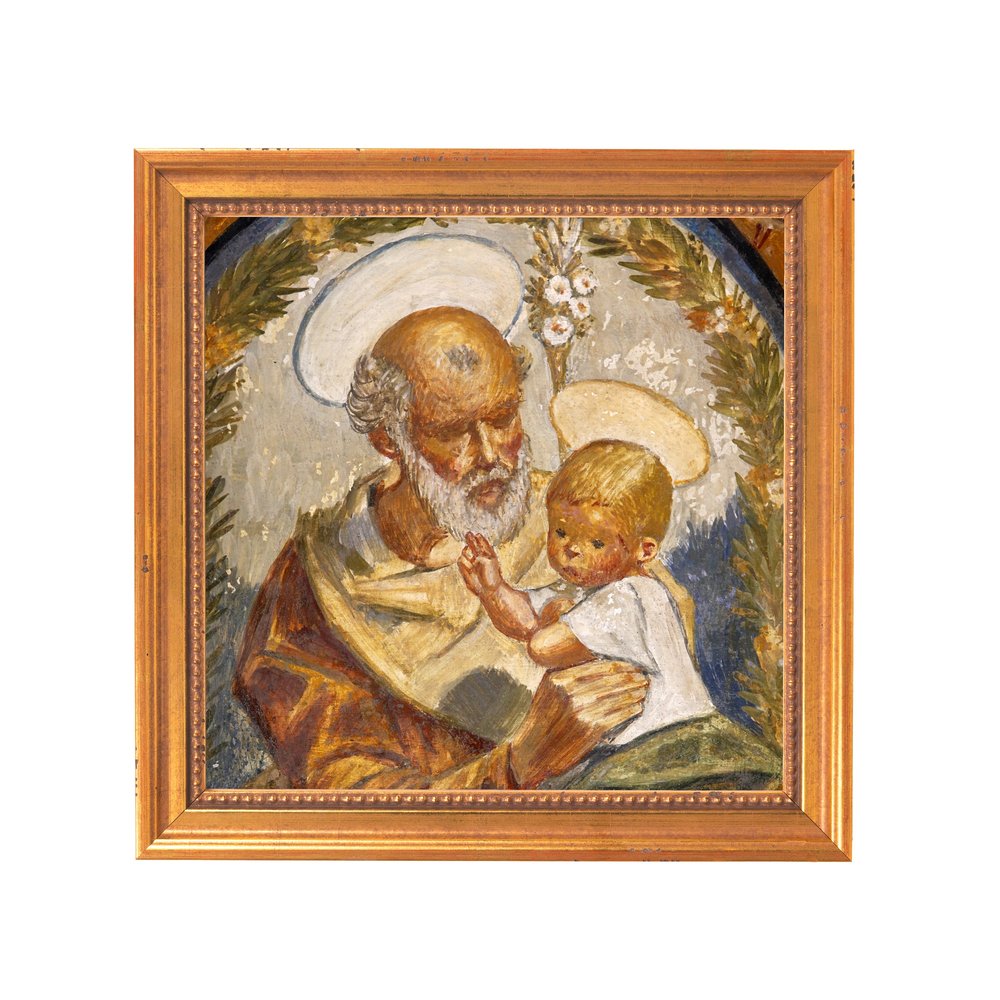 Framed oil painting of Saint Joseph holding the baby Jesus, with gold frame.