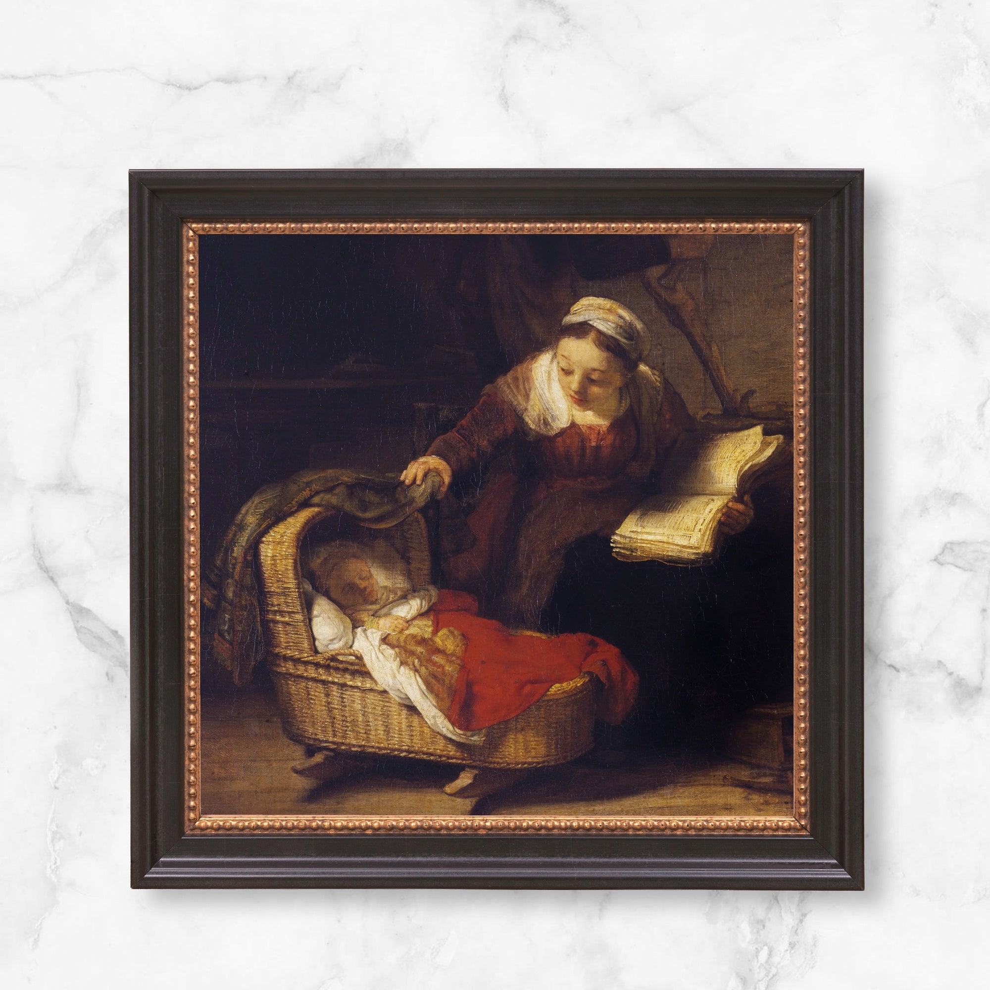 Framed oil painting "Mother Reading Beside a Cradle" in a dark wood frame with gold trim.