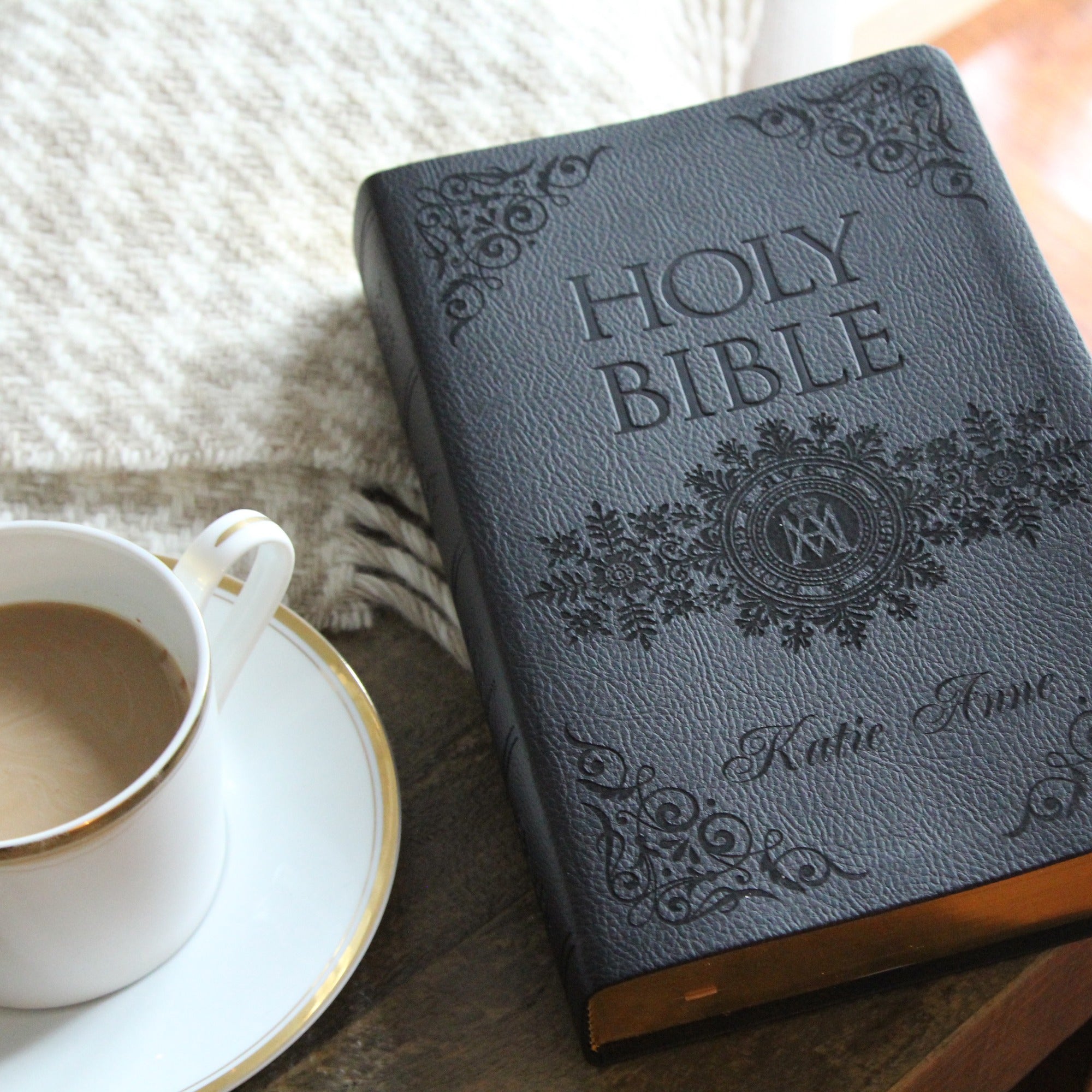 Black, Leatherbound Holy Bible with gold edging and decorative embossed design.