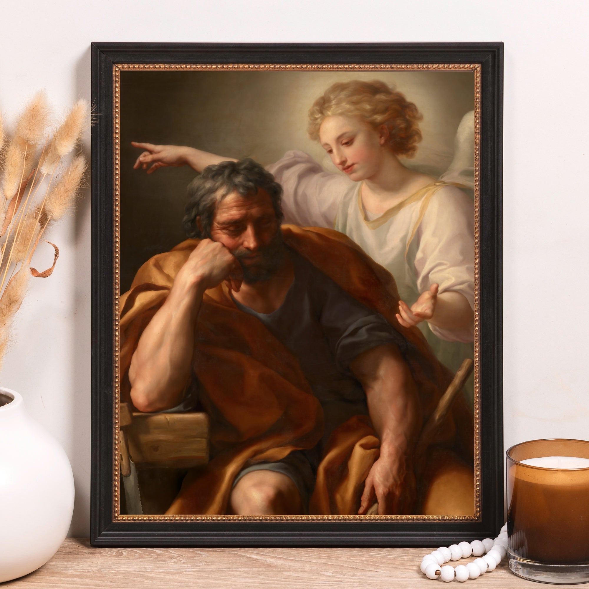 Framed painting of Saint Joseph being spoken to by an angel, in classic style with a black frame.