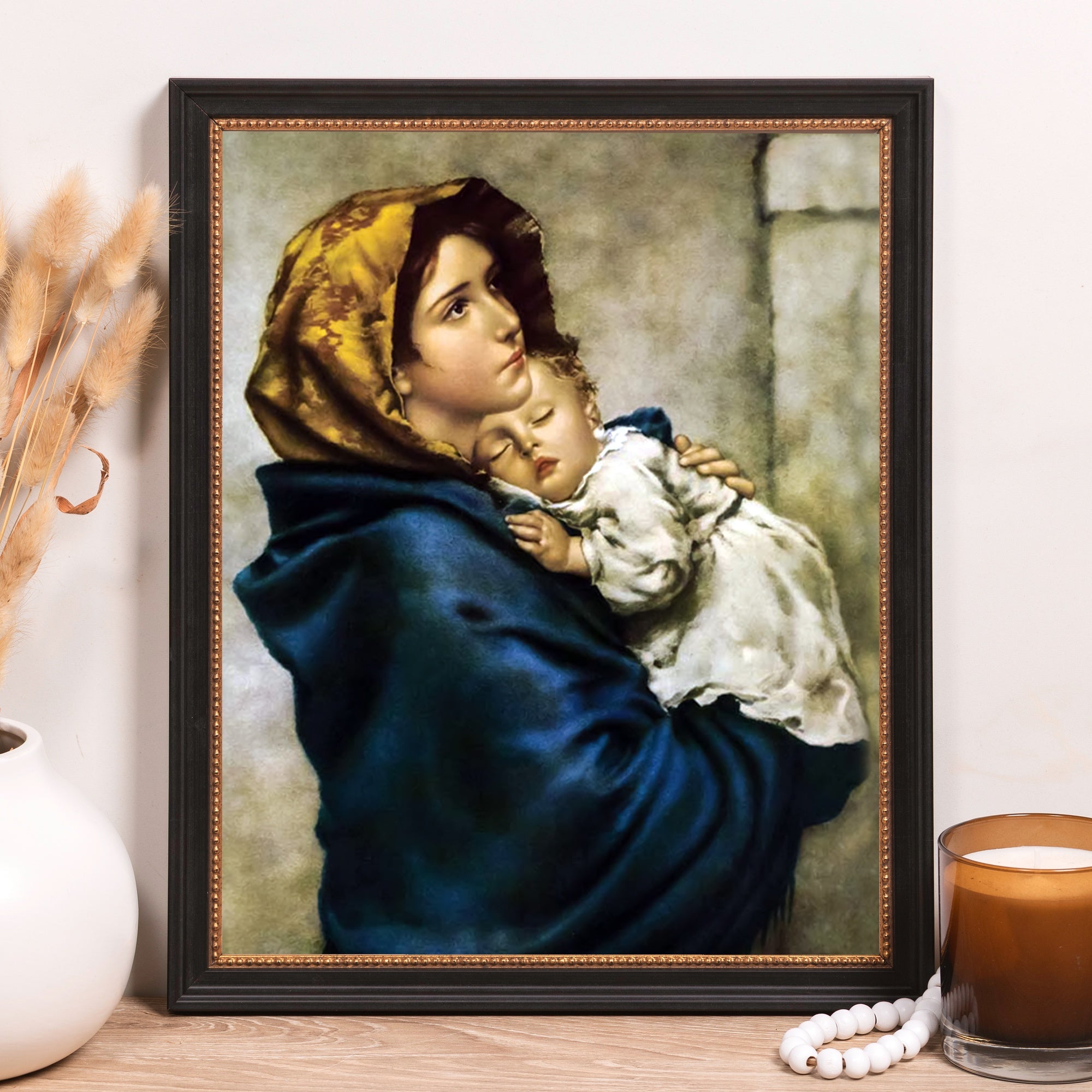 Framed Painting depicts mother holding child, classical style with blue cloak and gold headscarf.