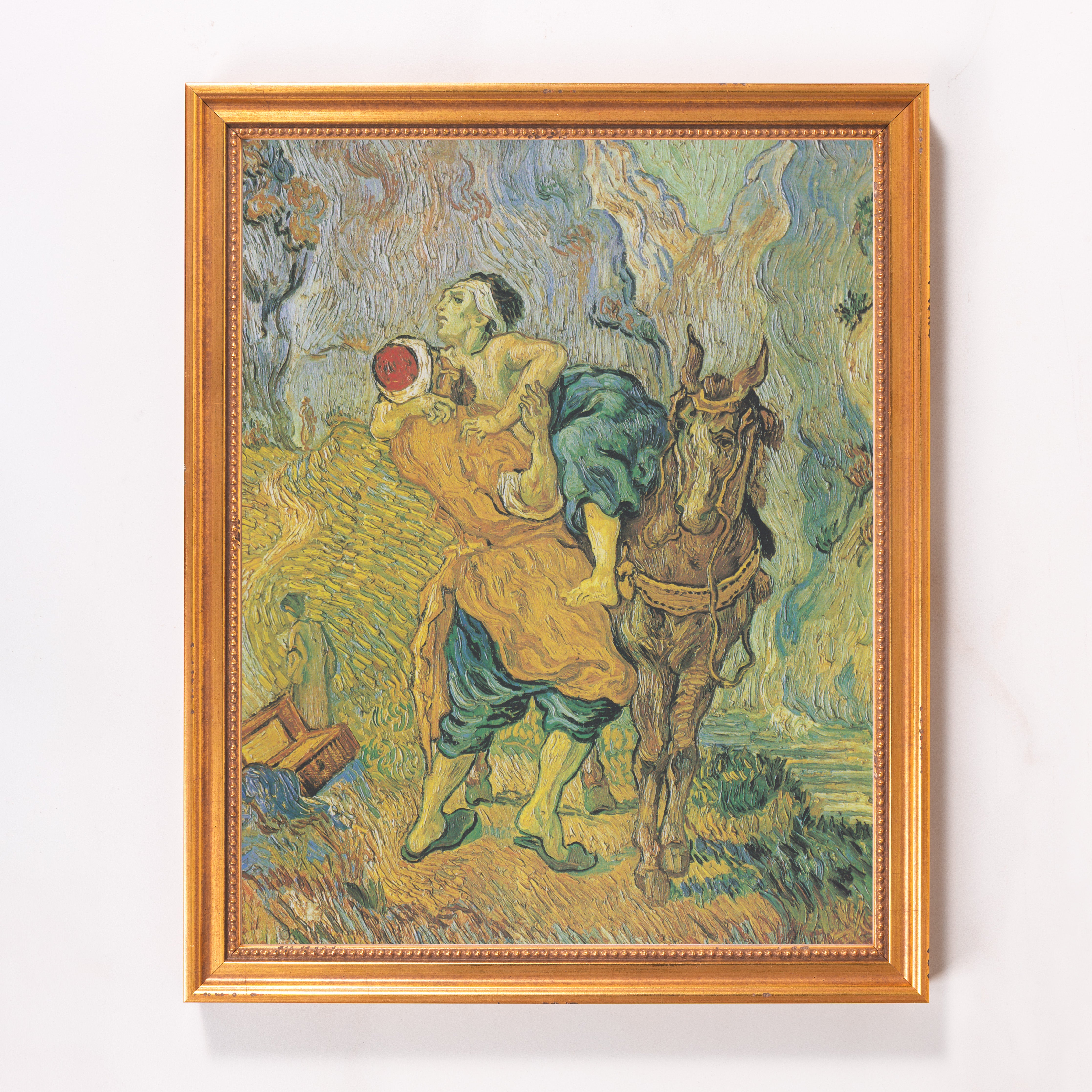 Framed reproduction print of Van Gogh's "Good Samaritan" in a gold frame.