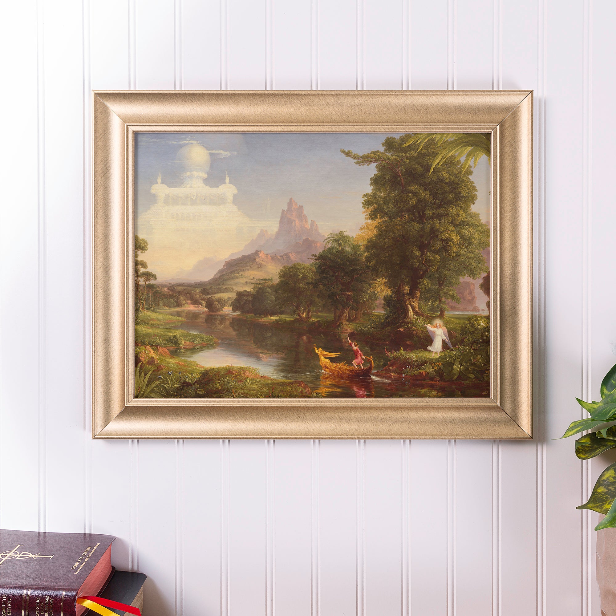 Framed landscape painting with gold-tone frame shows figures on a boat and an angel near a river.