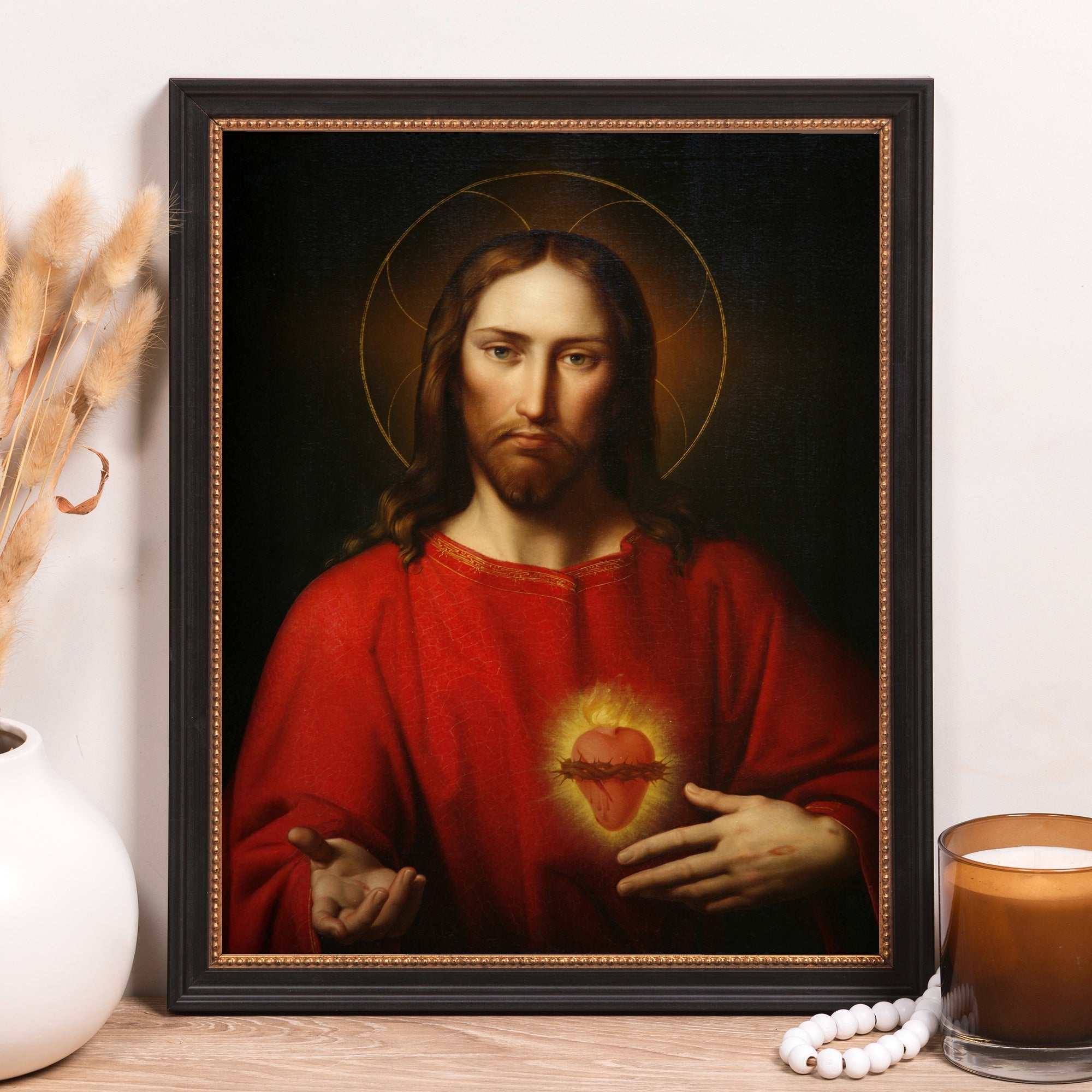 Framed Jesus portrait on canvas with a halo, wearing a red robe with a heart.