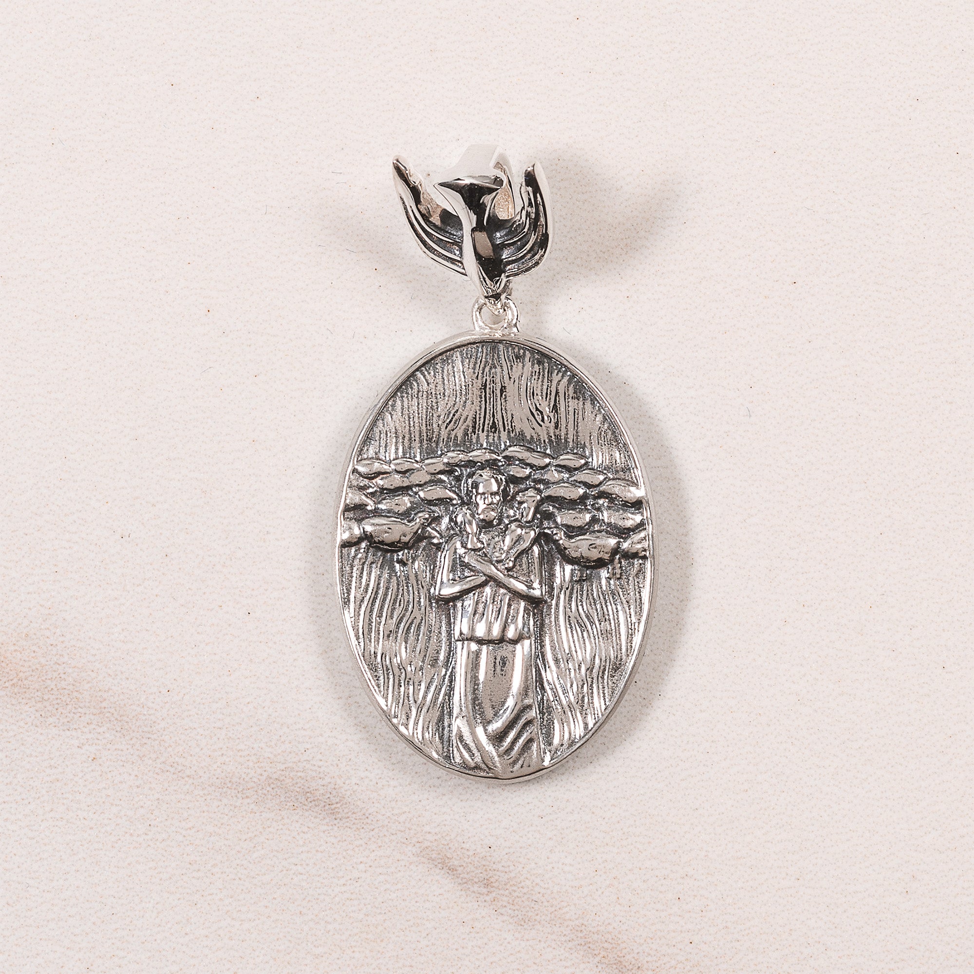 Silver, Oval pendant necklace showing shepherd holding lambs, with decorative bail.