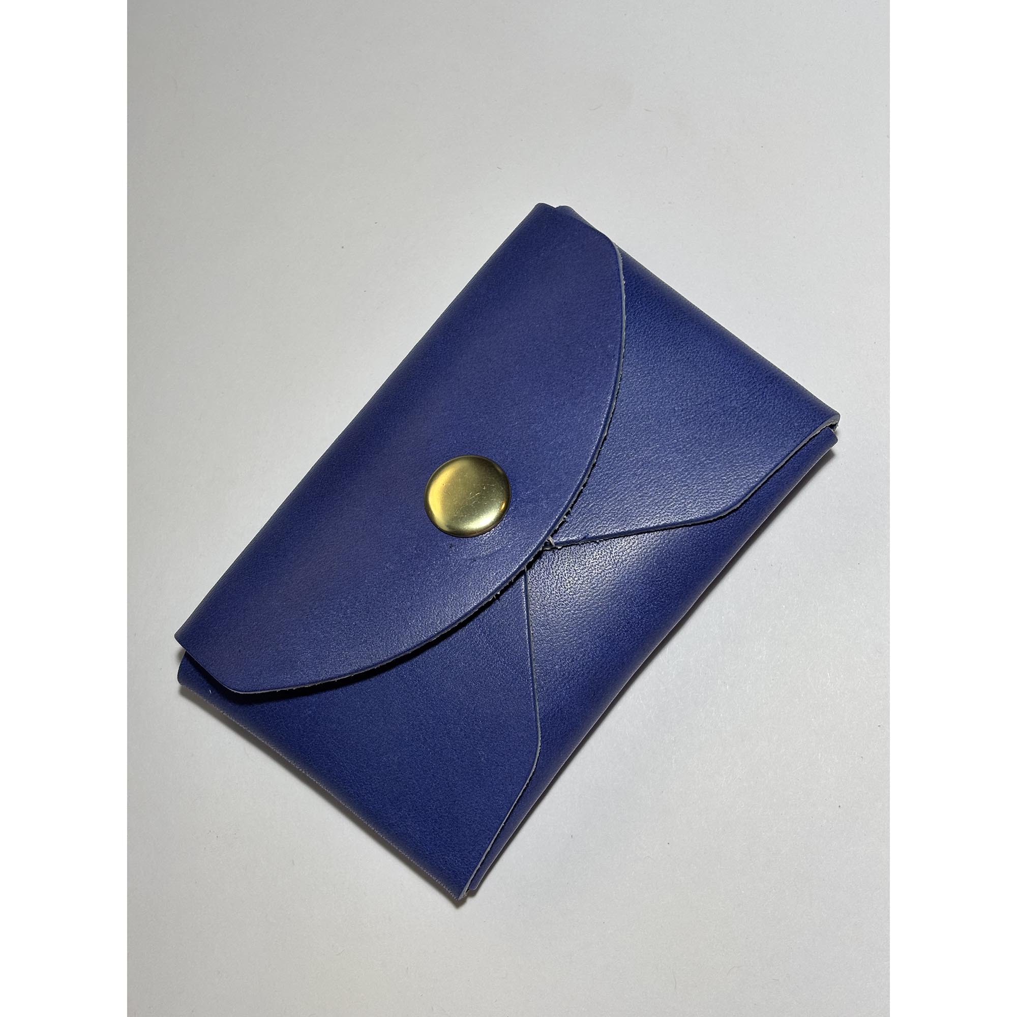 Blue leather card wallet with a brass snap closure.