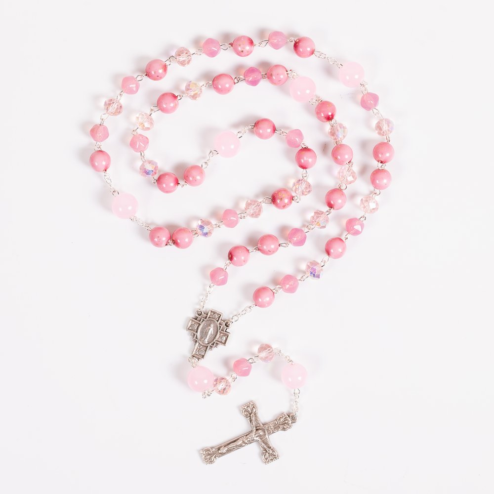 Pink rosary with a metal crucifix and cross, composed of round stone and crystal beads.