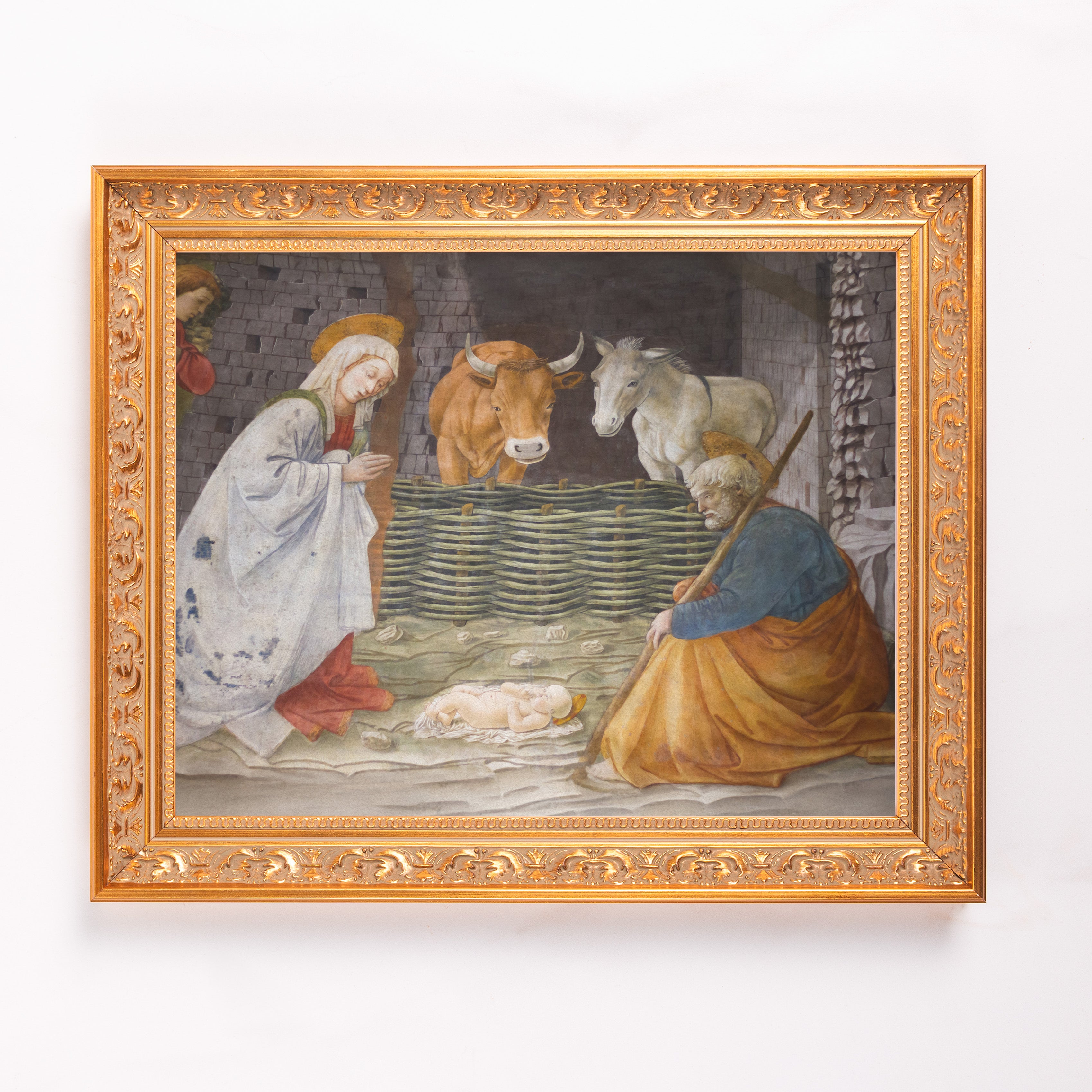 Framed Nativity scene shows Mary, Joseph, and Baby Jesus with animals in a traditional style.