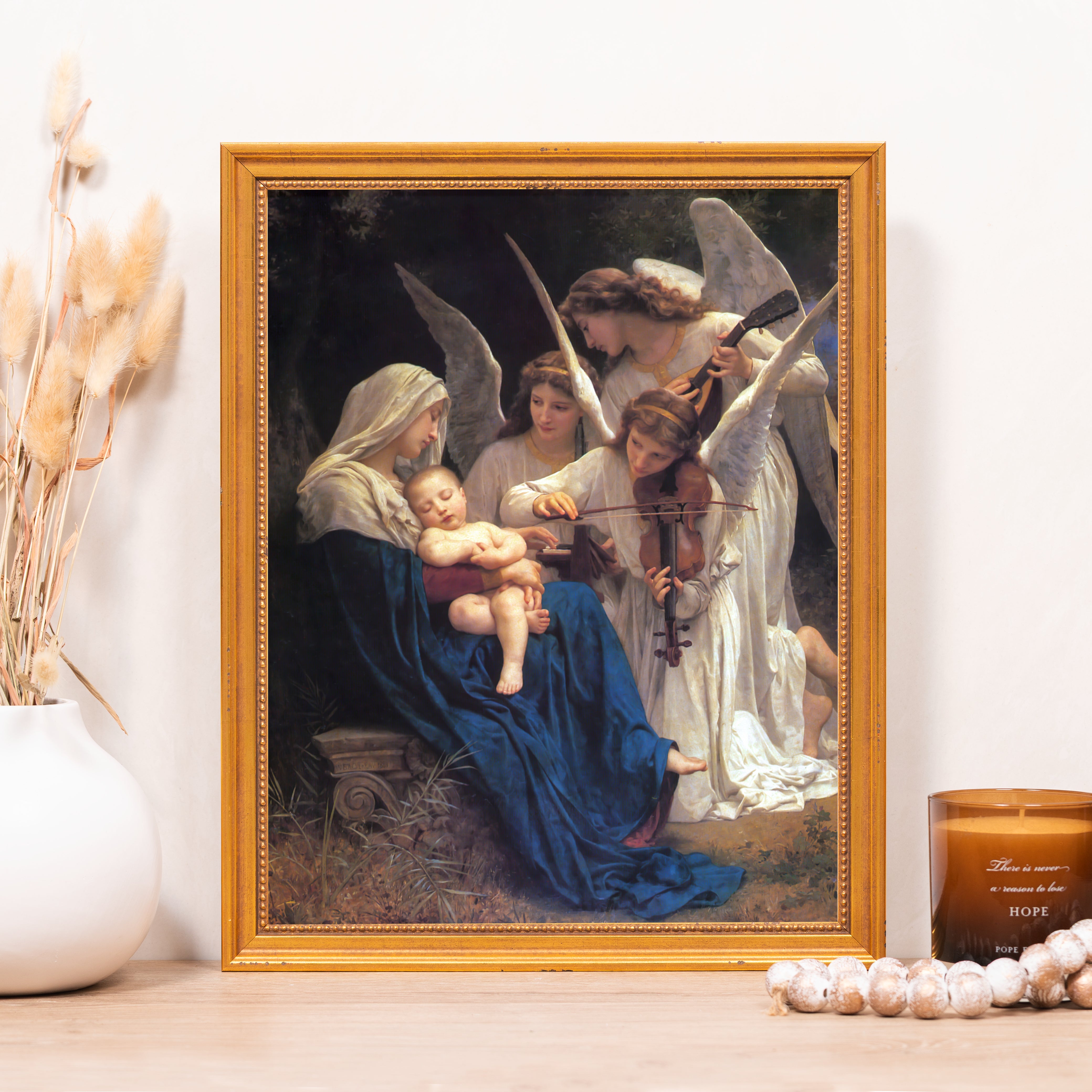 Framed reproduction print of Mary and baby Jesus being serenaded by angels in a gold-toned frame.