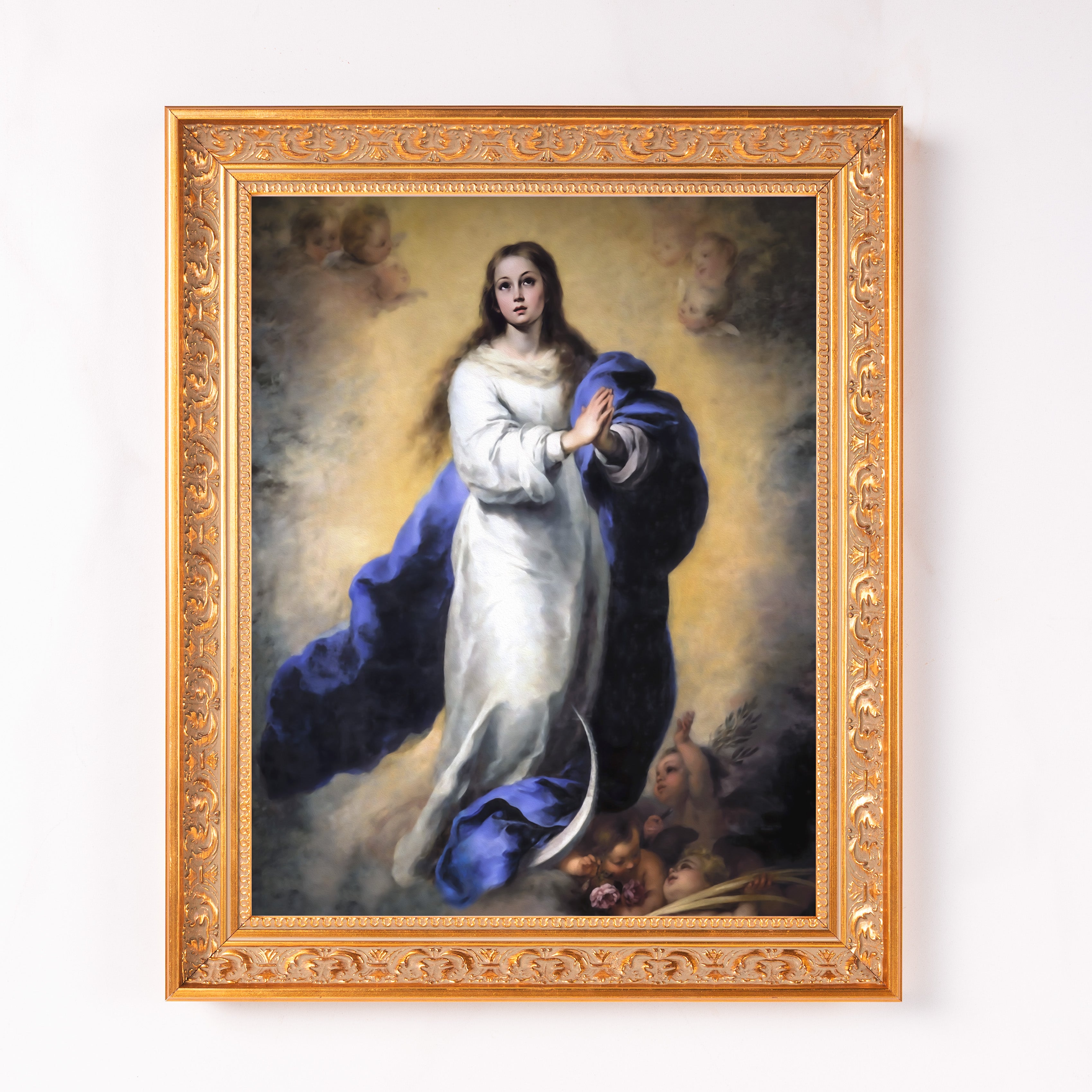Framed art of virgin mary painting with white robes and blue cape, ornate gold frame.