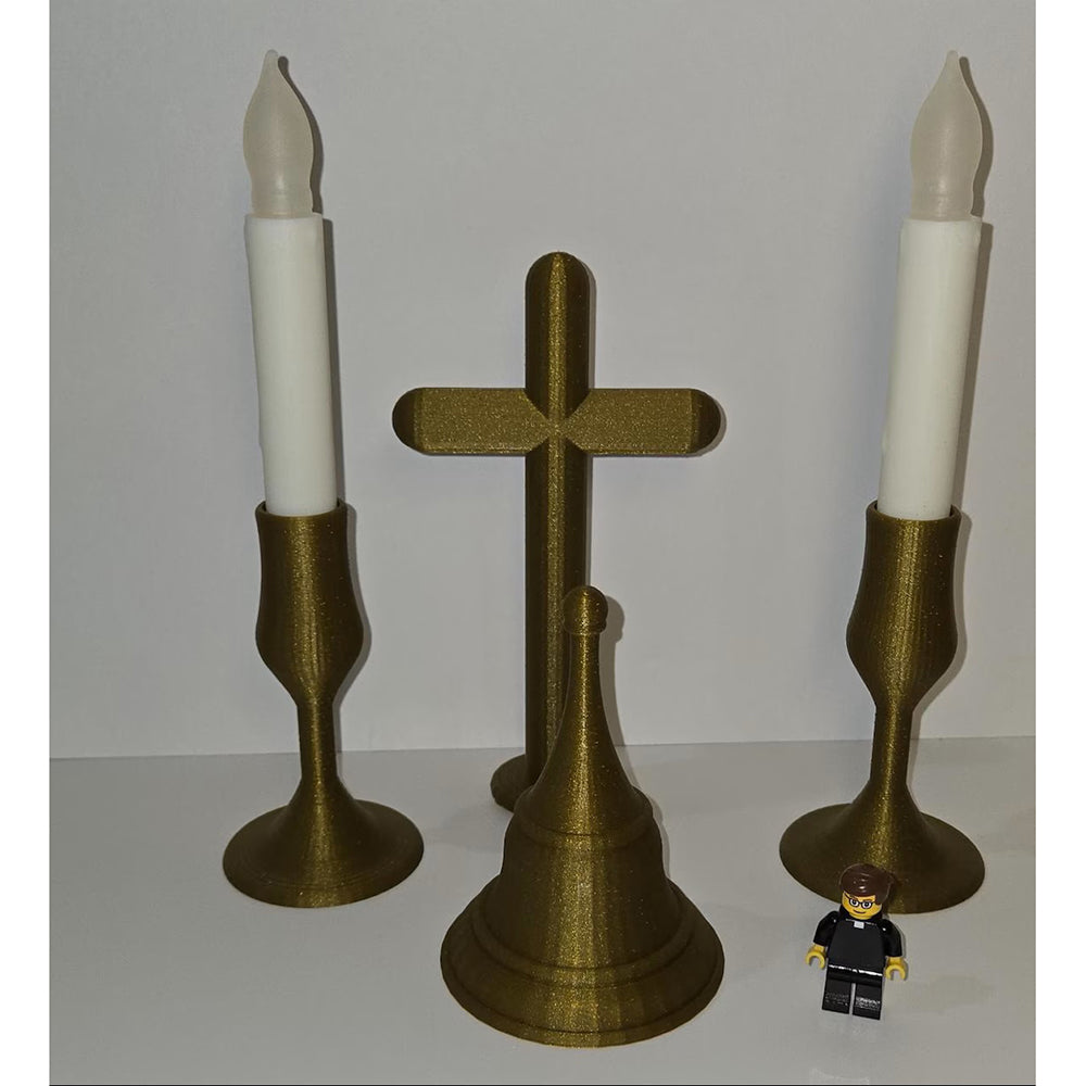 Golden, 3D-printed home altar set with a cross, bell, and two candlesticks holding electric candles.