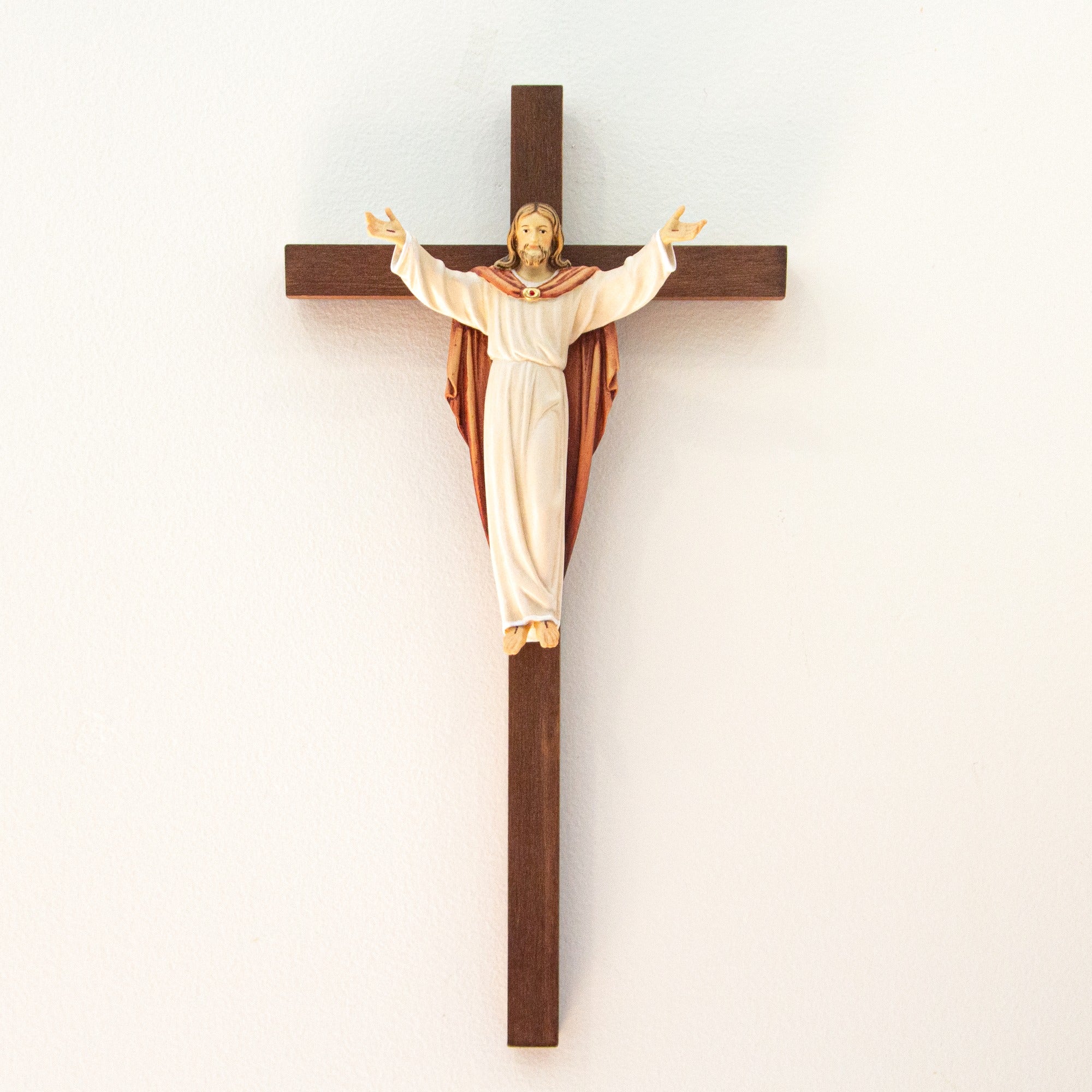 Crucifix featuring a wood cross and a resin figure of Jesus Christ with outstretched arms and a robe.