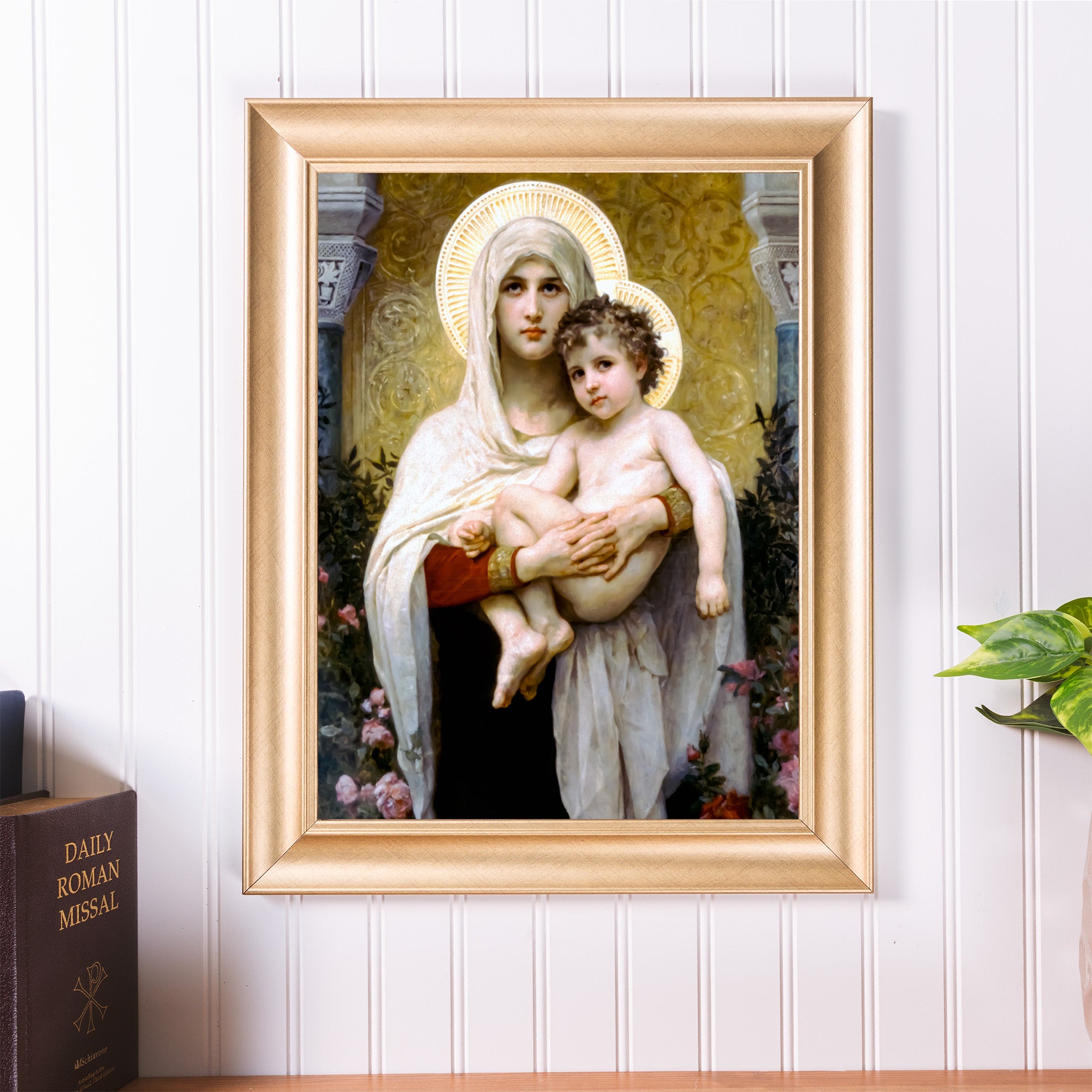 Framed Virgin Mary and Child art print in ornate gold frame, on a wall.