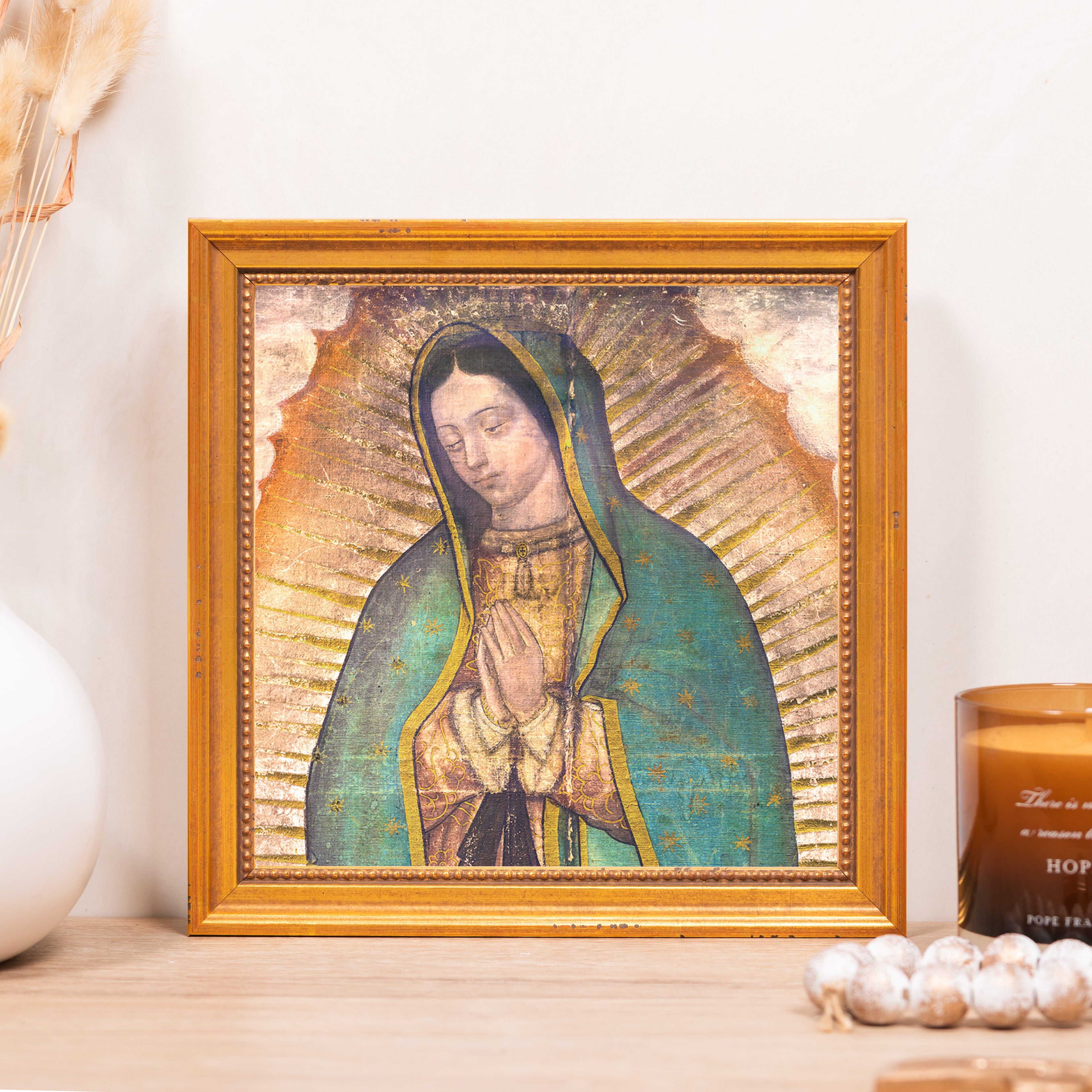 Framed Our Lady of Guadalupe print with a gold frame and blue, green, and gold hues.