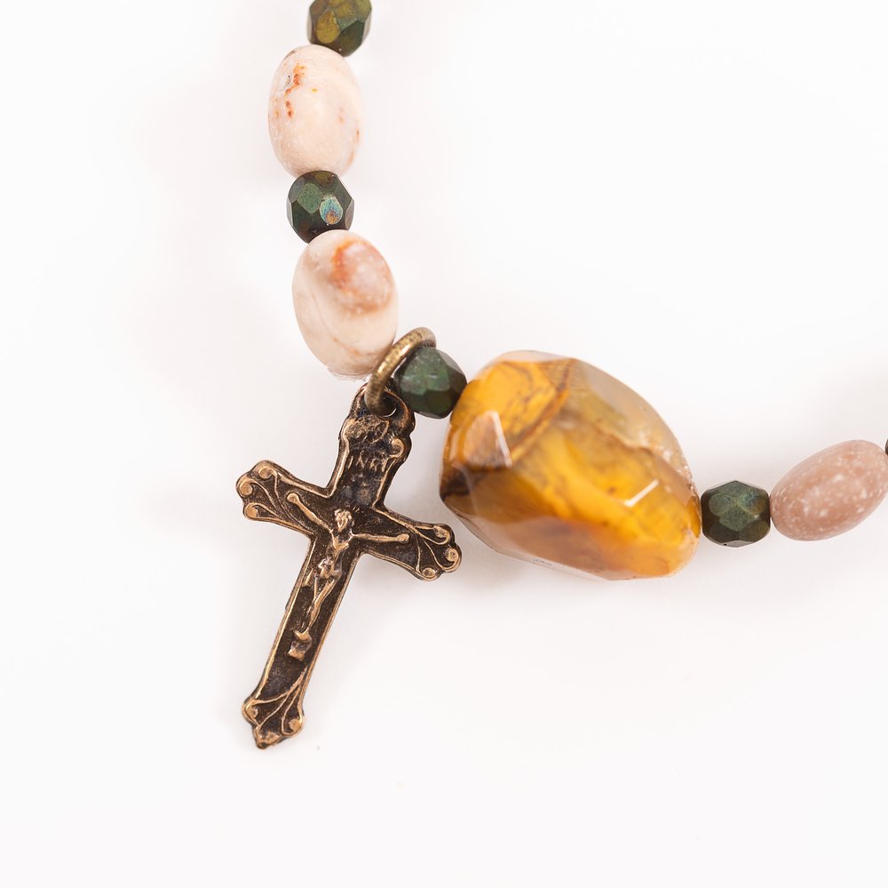 Rosary with tan, pink, and green stone beads and a bronze crucifix.