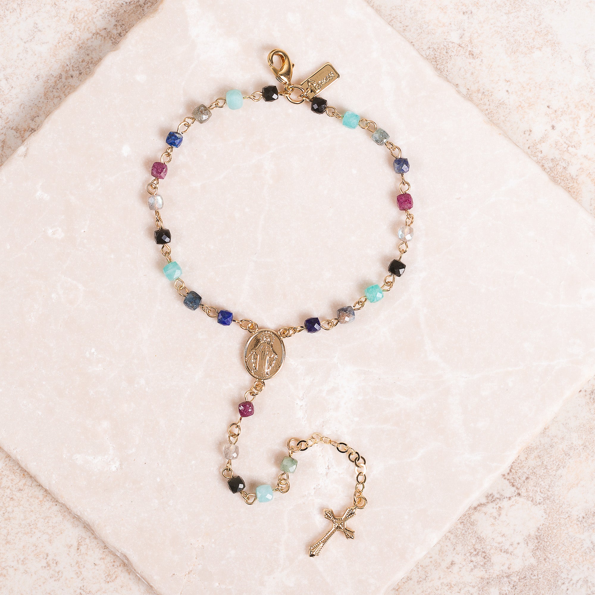 Gold rosary bracelet with colorful beads and cross charm.
