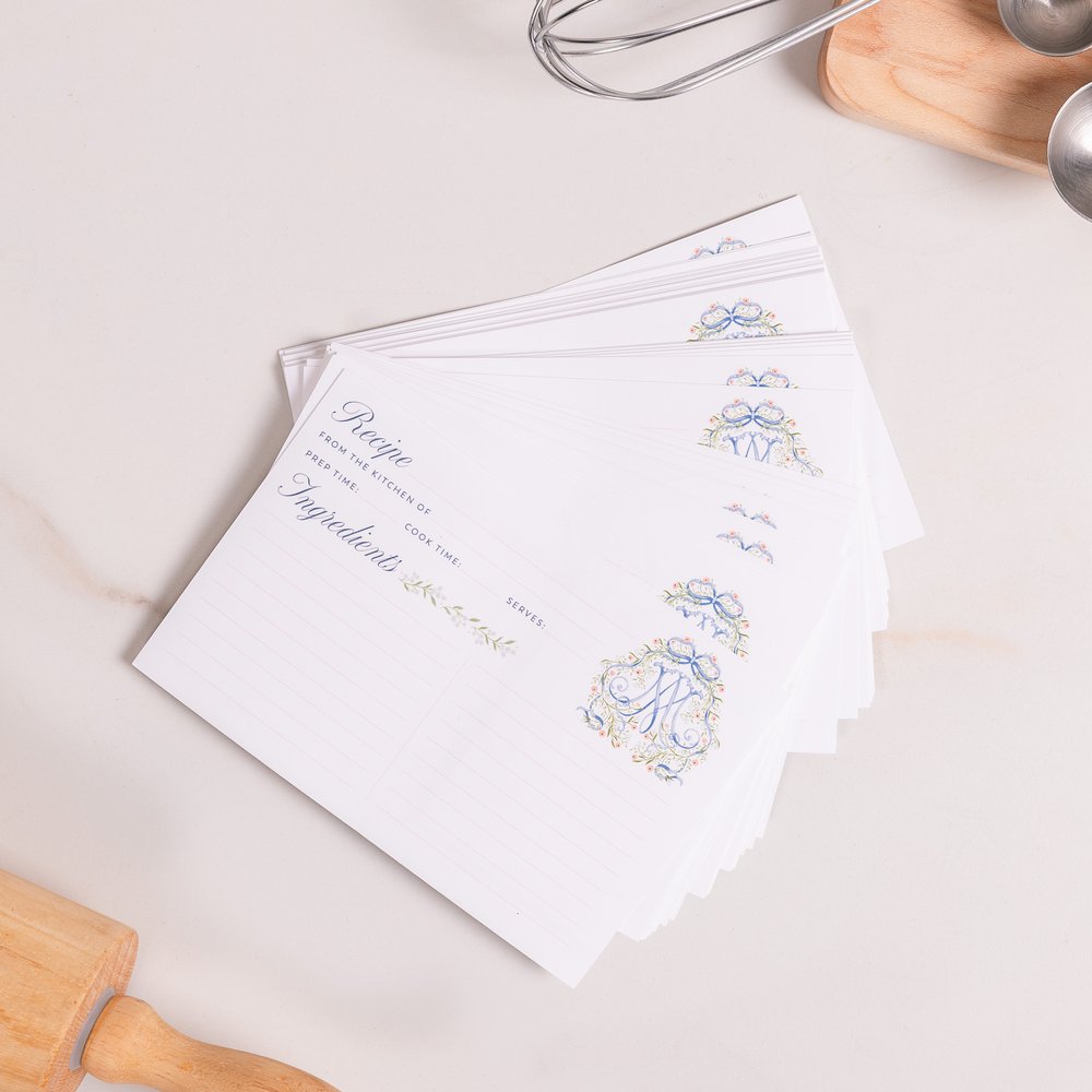 Stack of white recipe cards with floral design and text space for recipe information.
