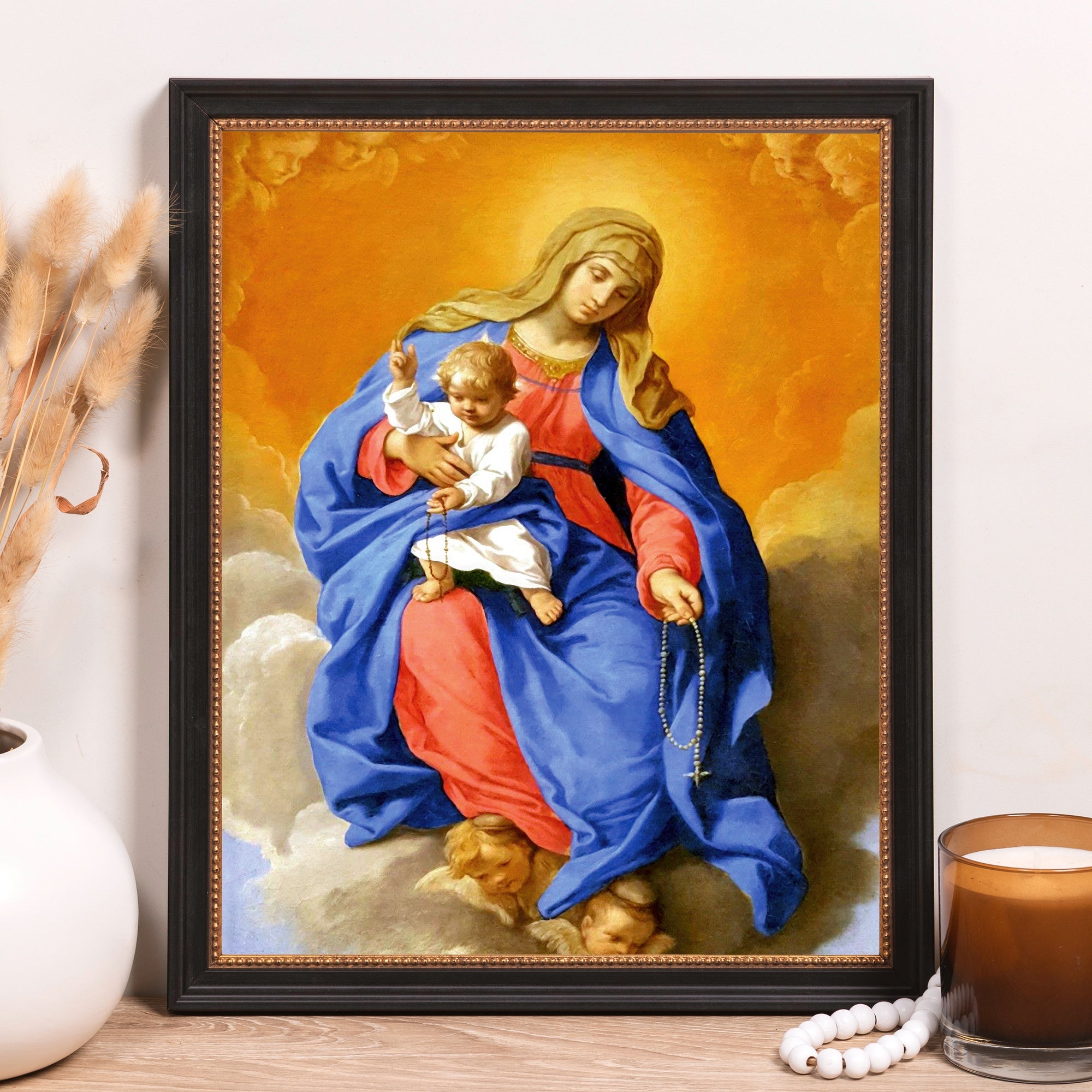 Religious painting of Virgin Mary holding baby Jesus with rosary, in black frame.