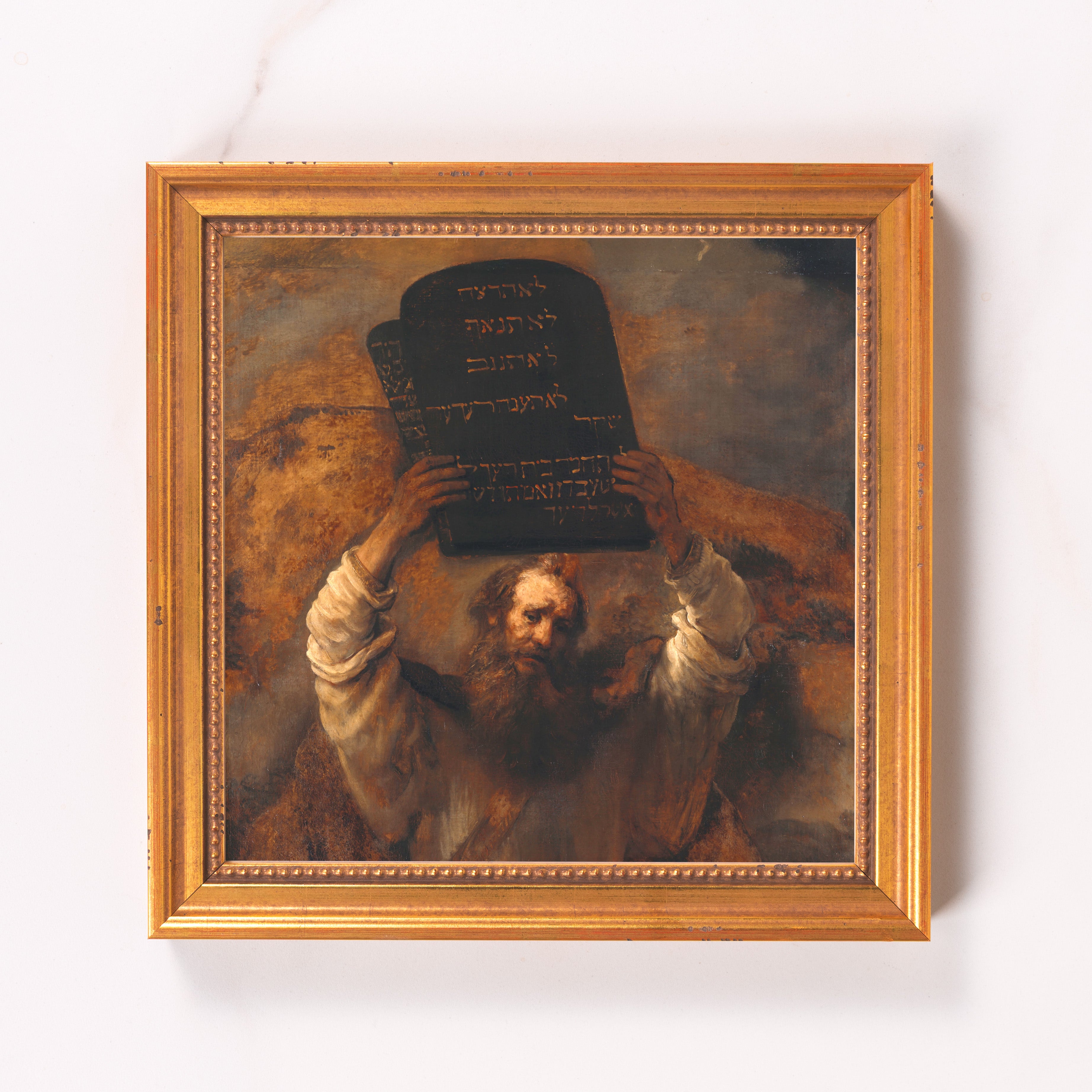 Framed painting of Moses holding the Ten Commandments, gold frame.