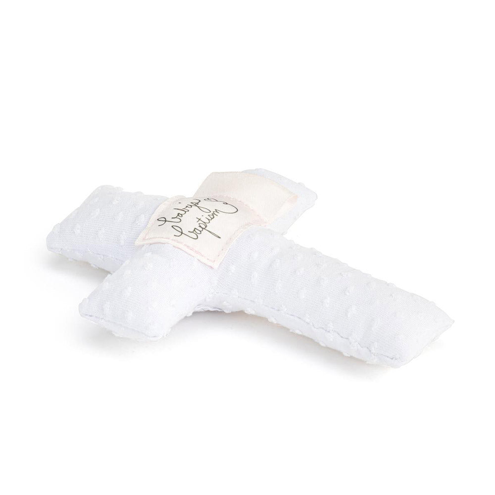 White, fabric, cross-shaped baby baptism pillow with small raised dots and a "Baby's Baptism" tag centered.