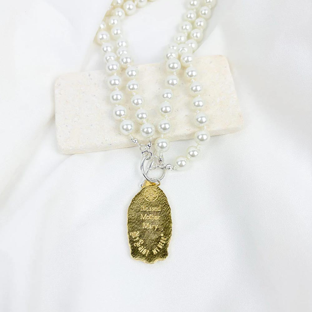 Elegant, double-strand pearl necklace with gold Blessed Mother Mary pendant and silver toggle clasp closure.