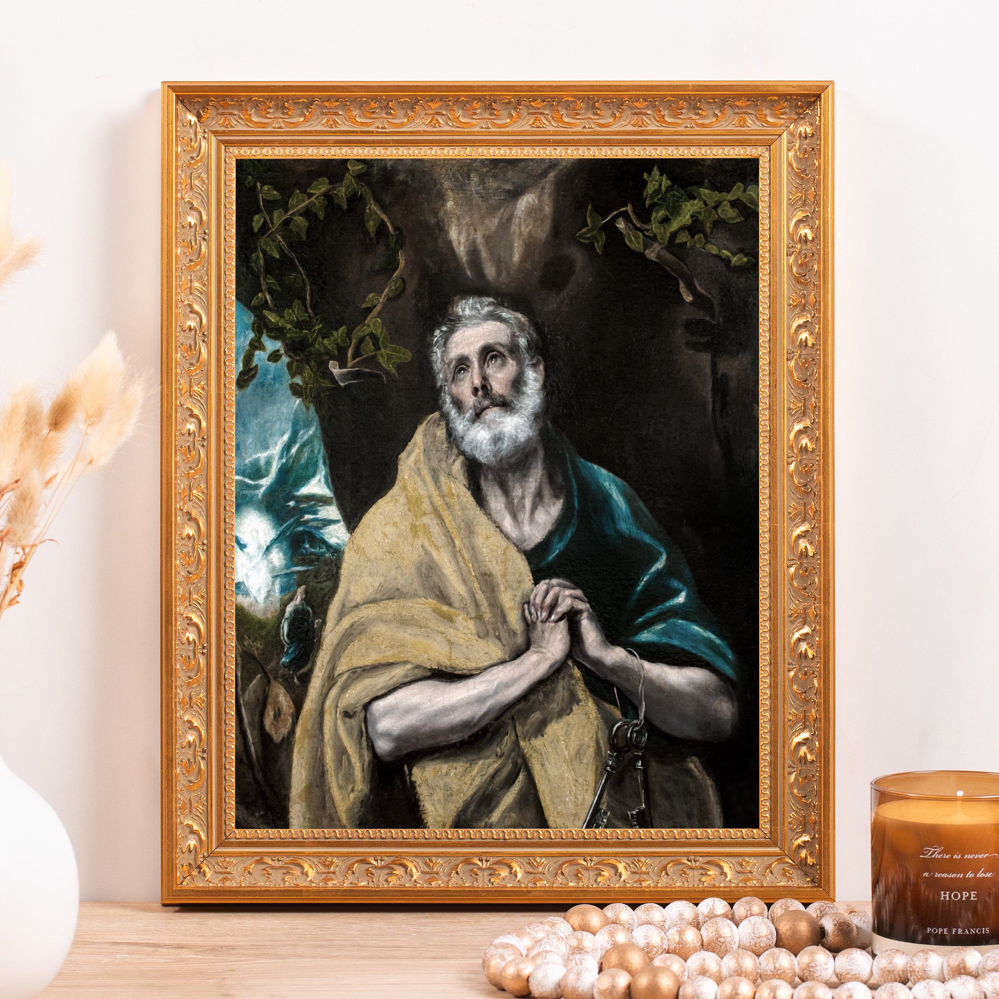 Framed painting of praying saint with keys, in a gold ornate frame.