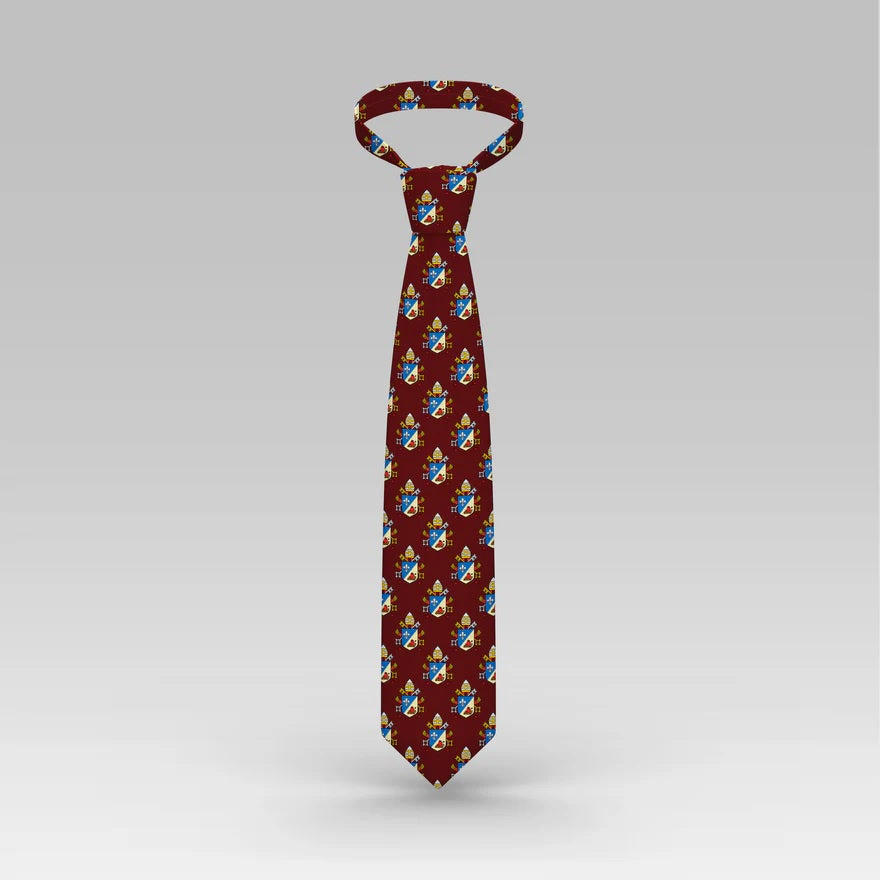 Burgundy tie with an all-over coat-of-arms pattern in blue, gold, and white.