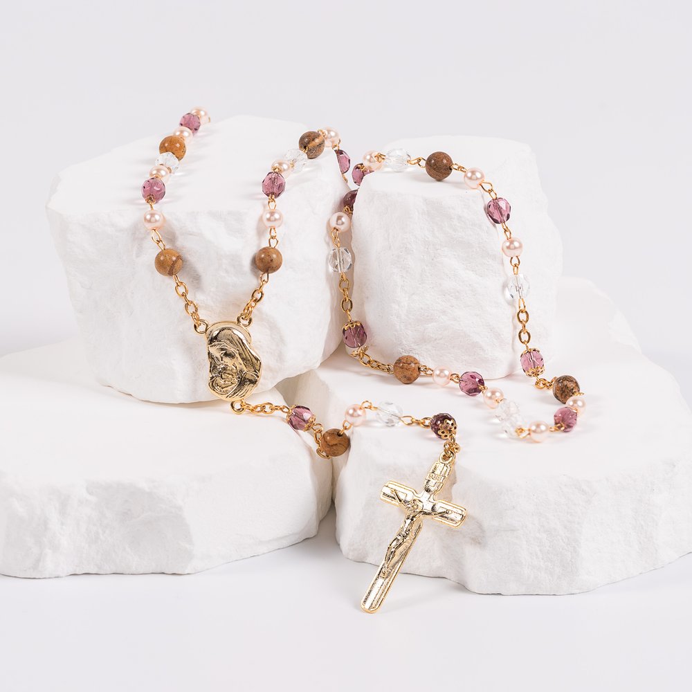 Beaded rosary with gold crucifix, featuring clear, brown, pink and lavender beads.