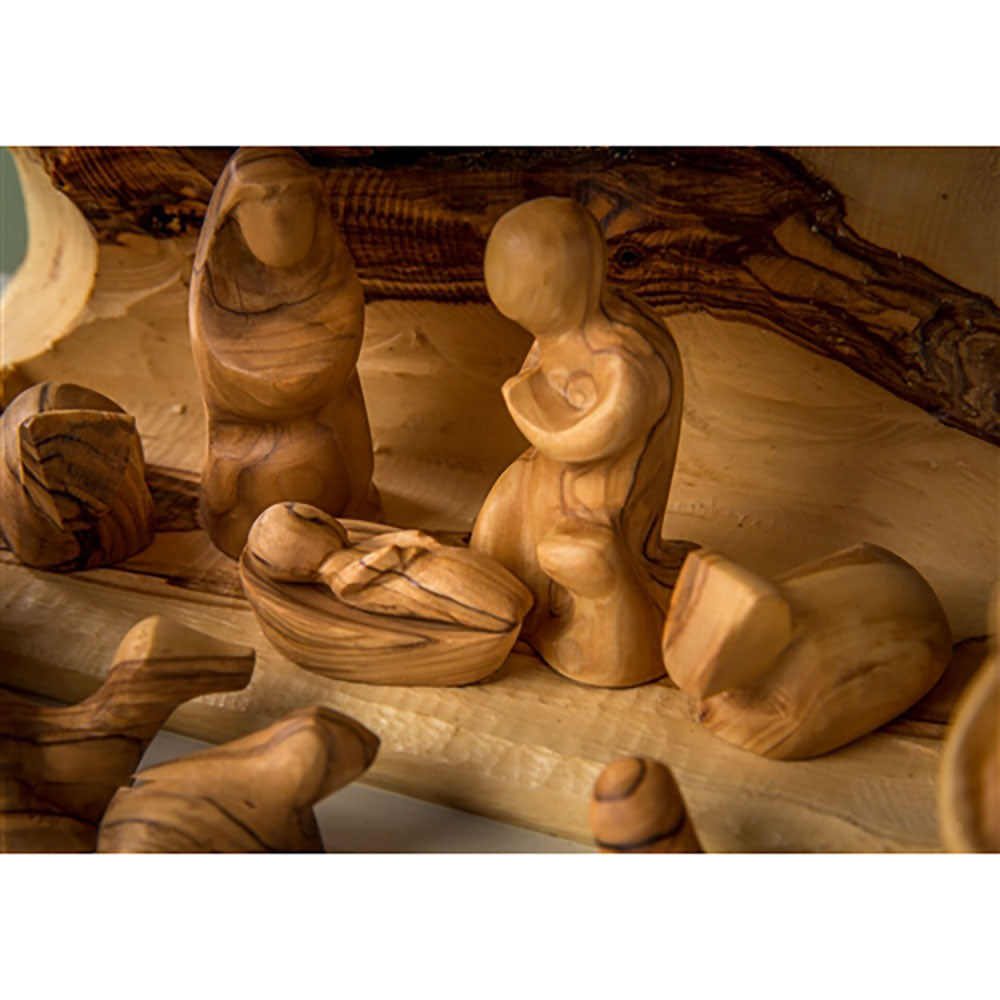 Olivewood Nativity scene with faceless figures, rustic style, and warm brown wood grain patterns.