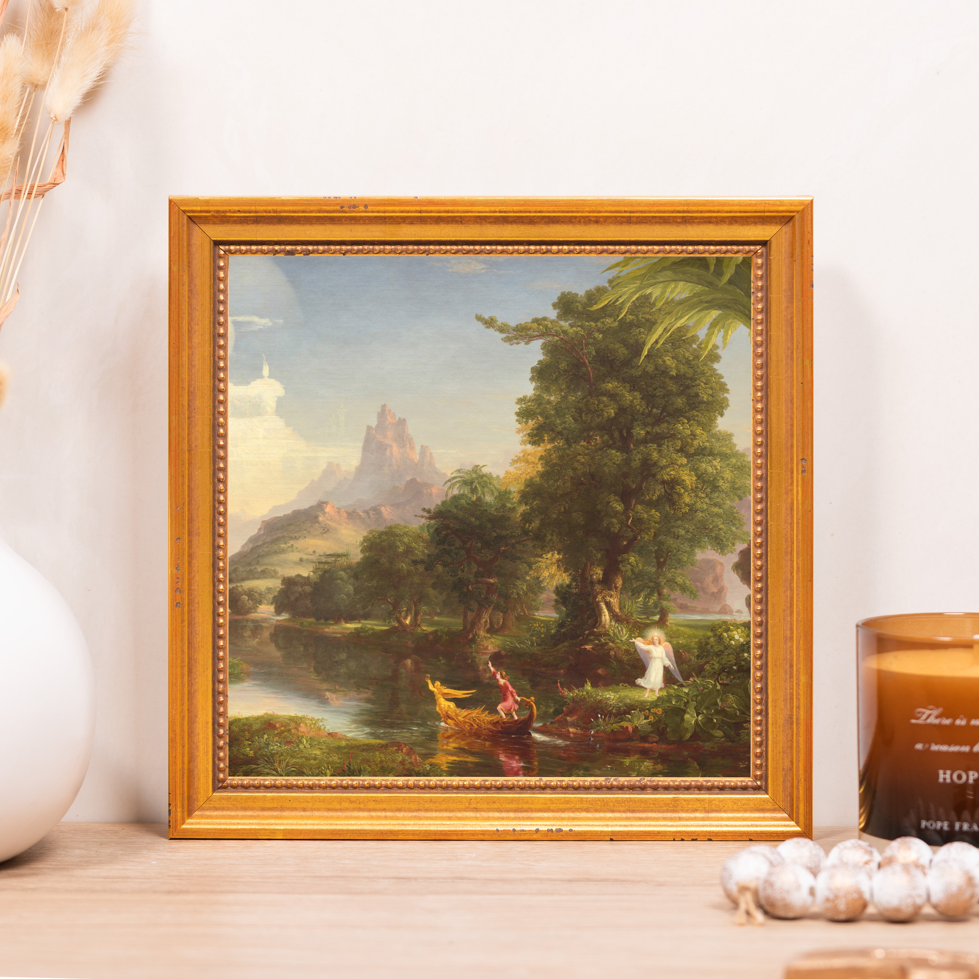Framed painting of a river landscape with a golden frame.