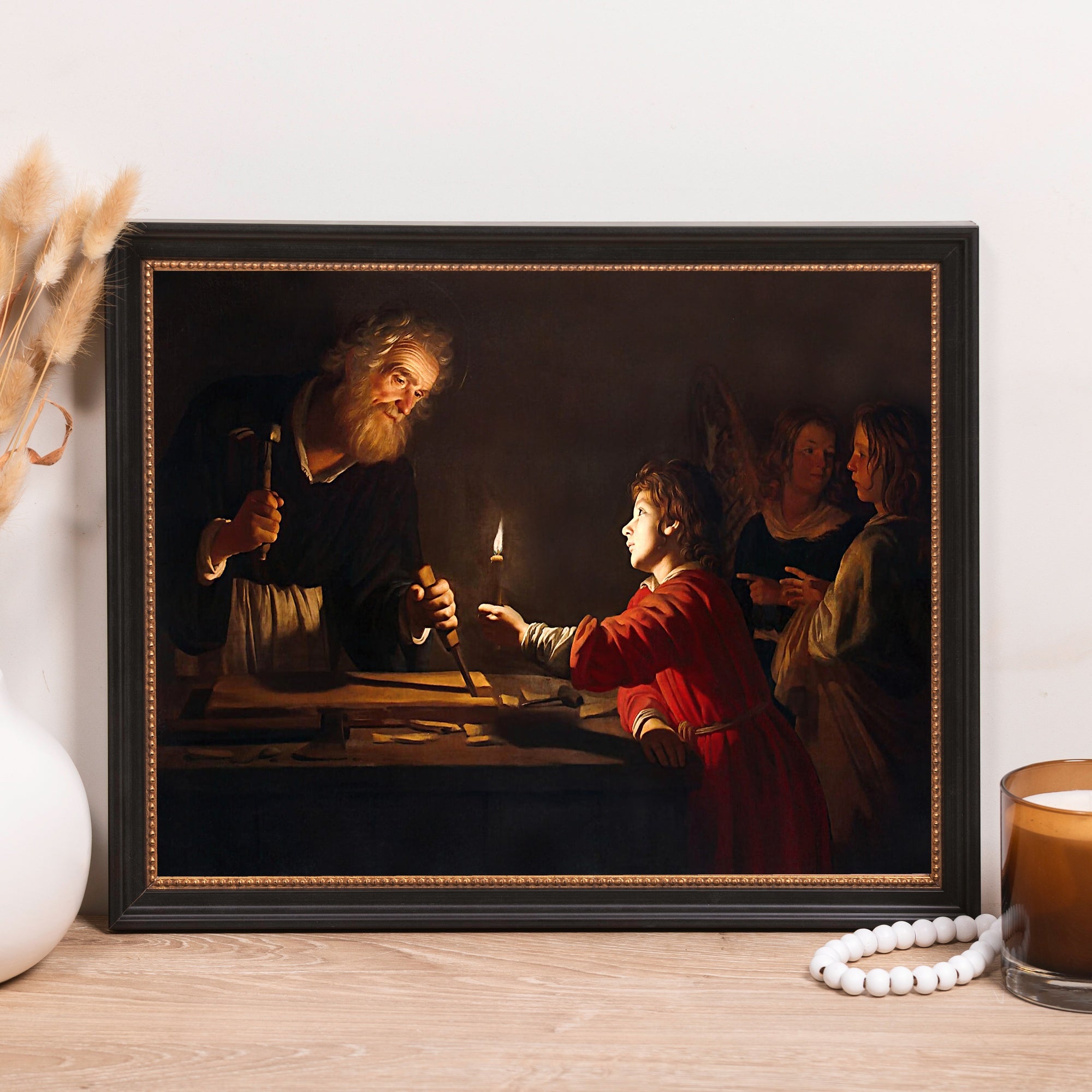 Framed reproduction of "Saint Joseph the Carpenter" painting, showing Joseph and young Jesus, in a black frame.