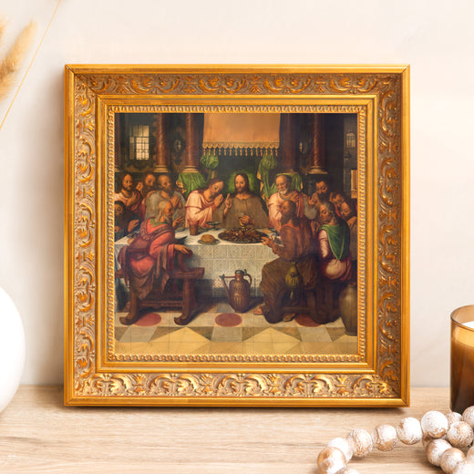 Framed painting depicting The Last Supper in an ornate gold frame hanging on a wall.