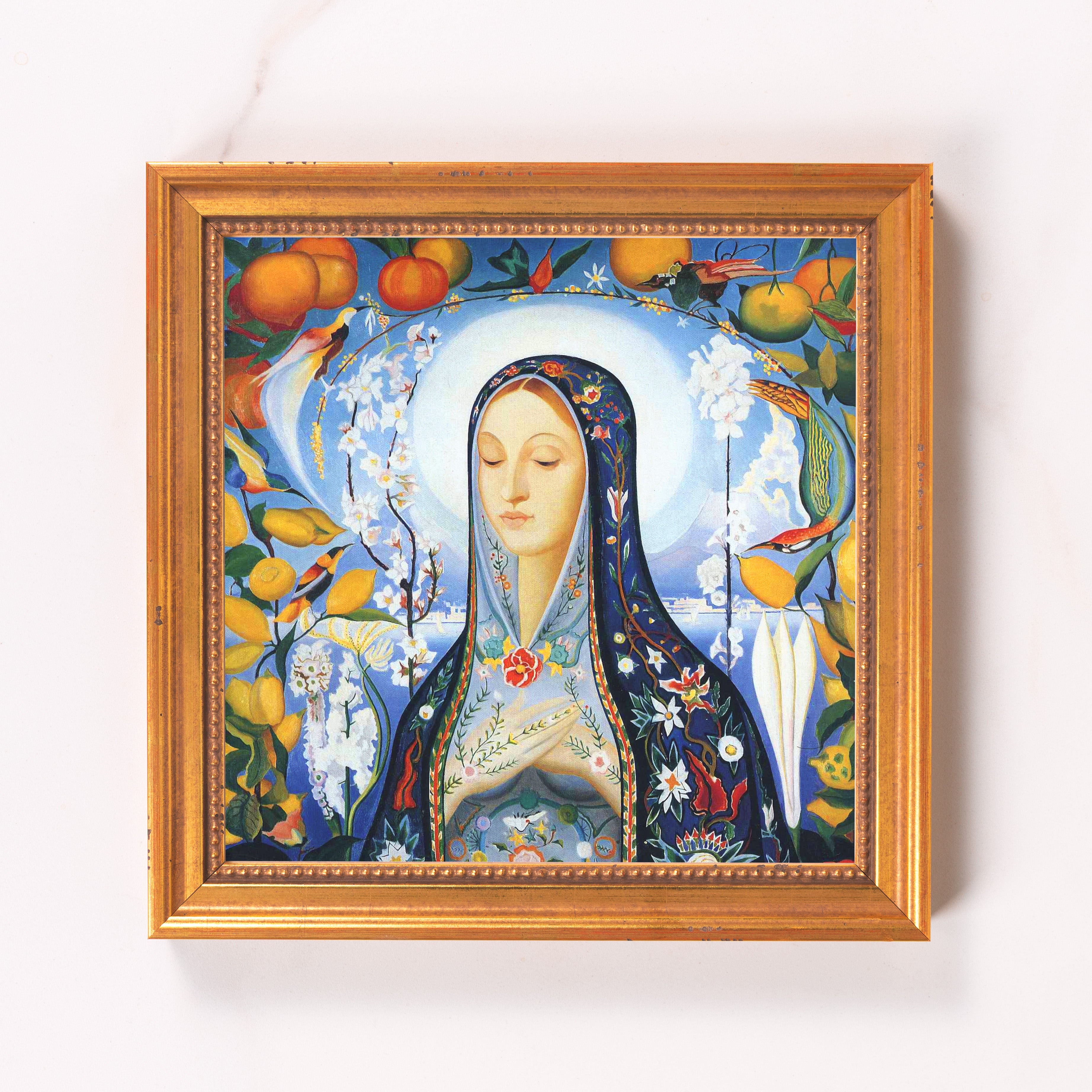 Framed religious painting showing a woman with a blue floral shawl in a golden frame.