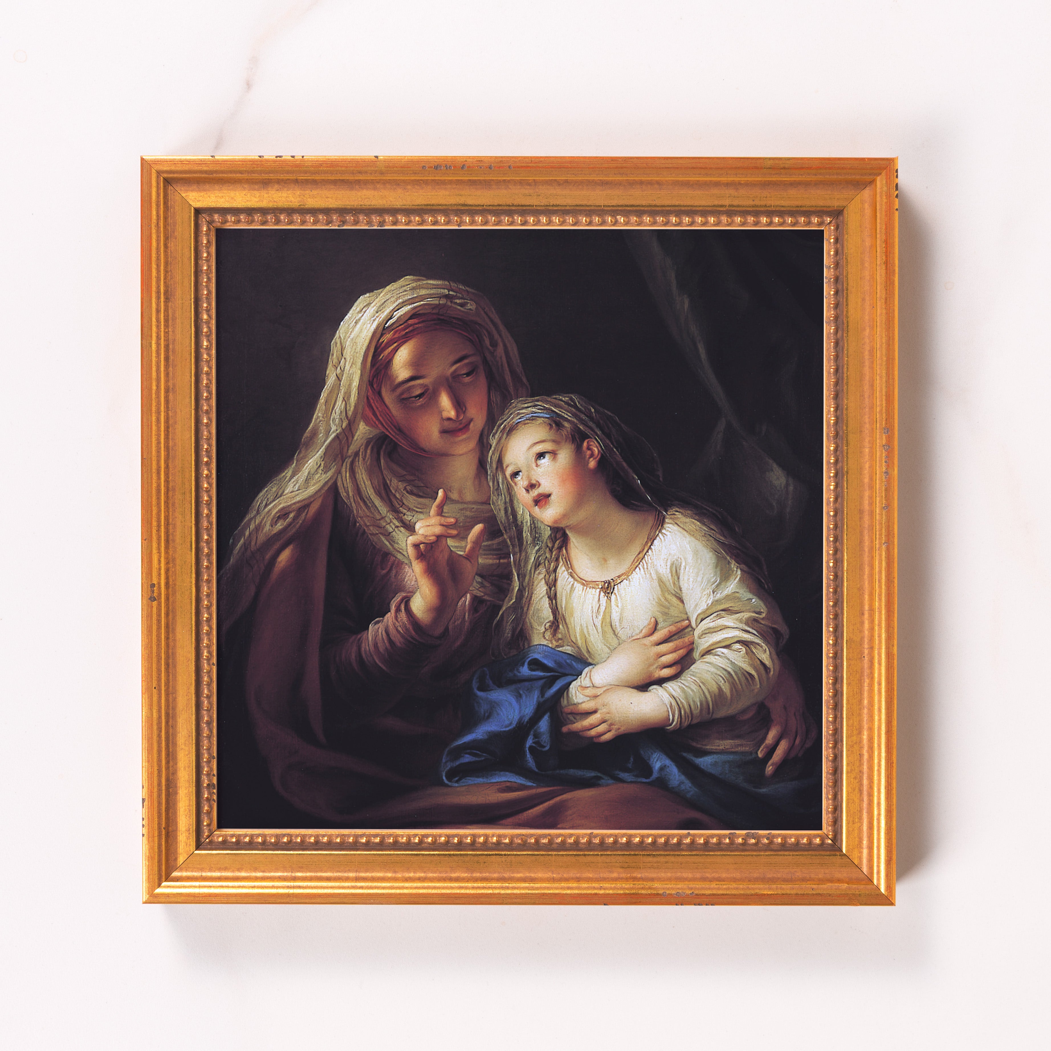 Framed oil painting of mother and child with gold frame, dark background.