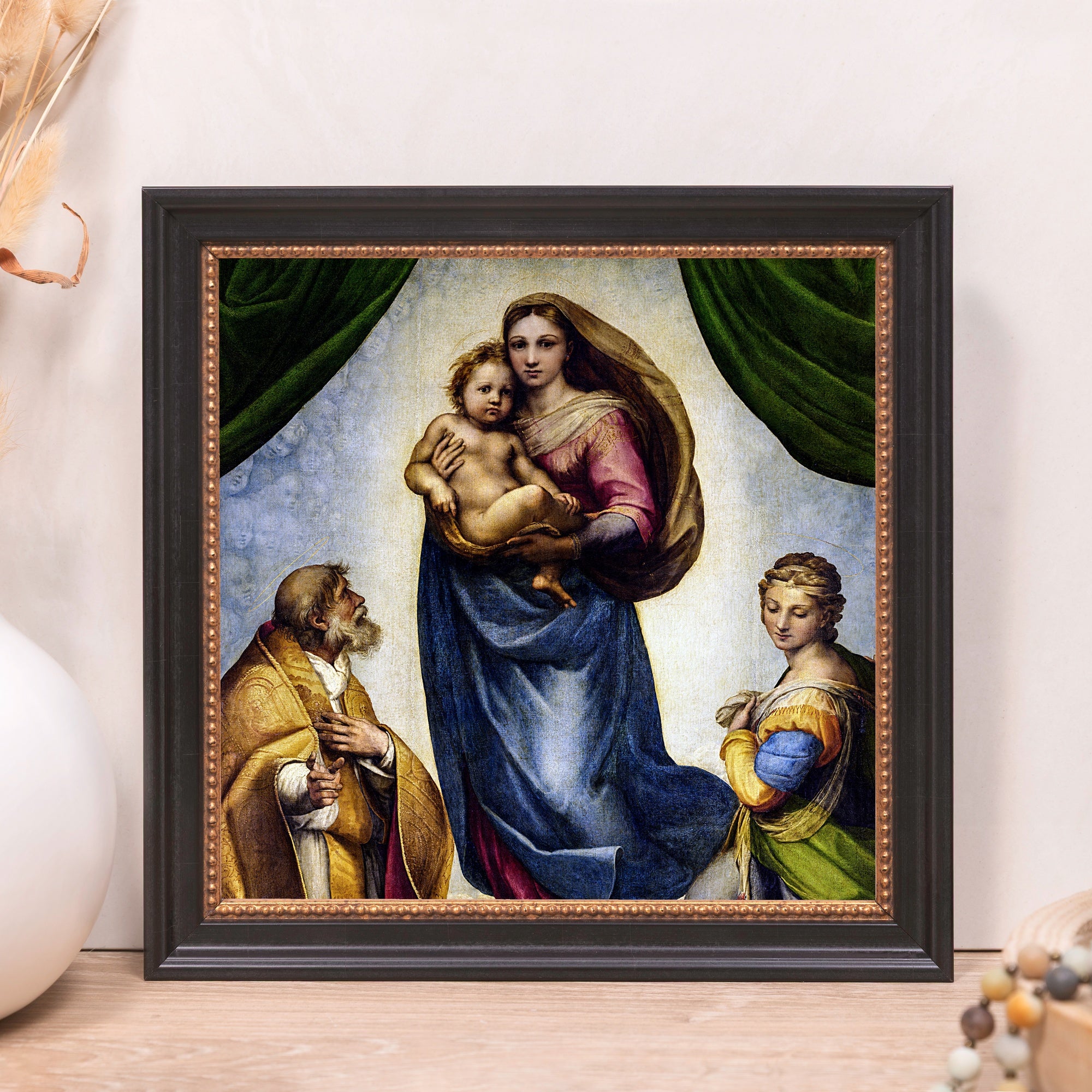 Framed painting of Raphael's Sistine Madonna featuring Mary, baby Jesus, and onlookers.