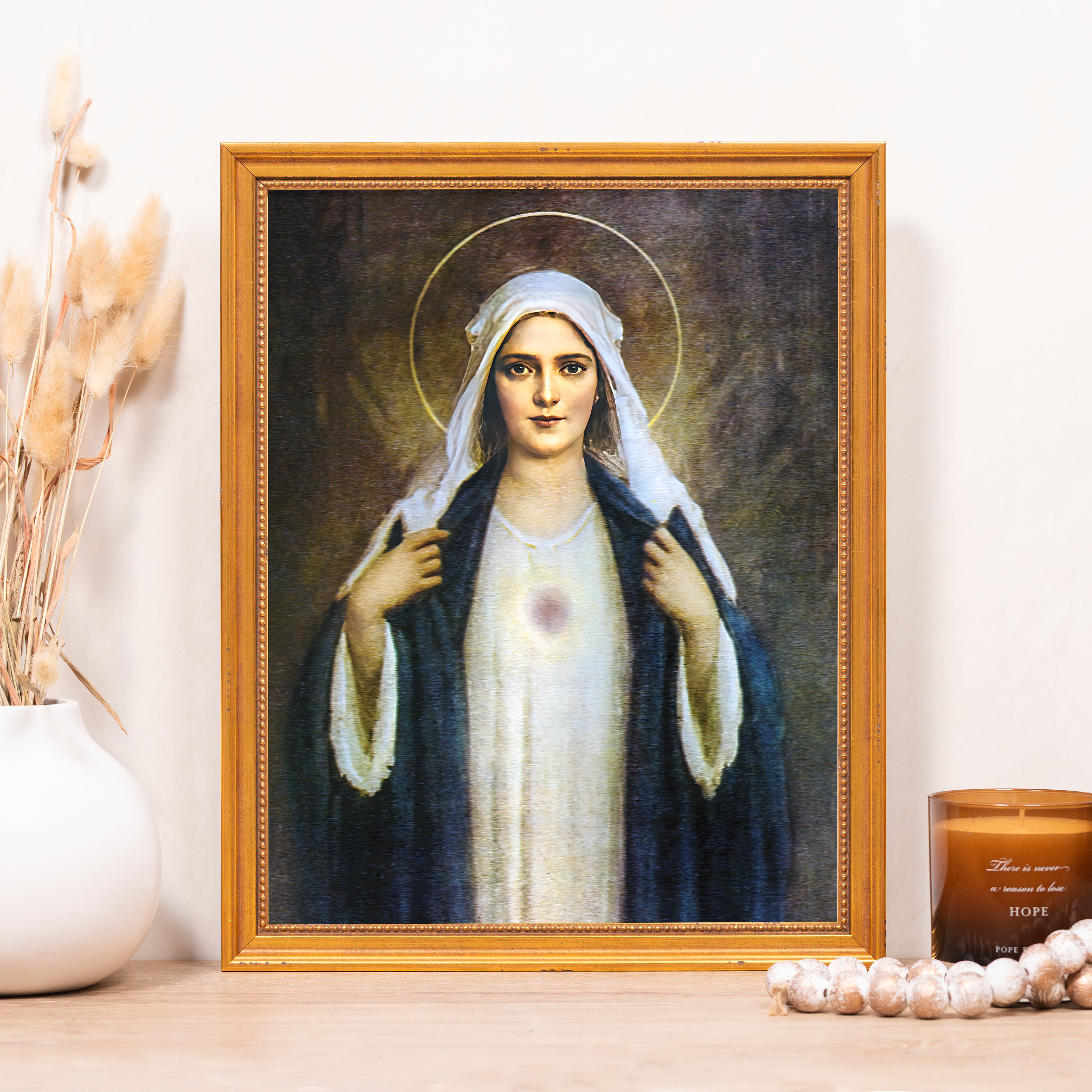 Framed portrait of Our Lady of Hope with white veil and blue cloak in gold frame.