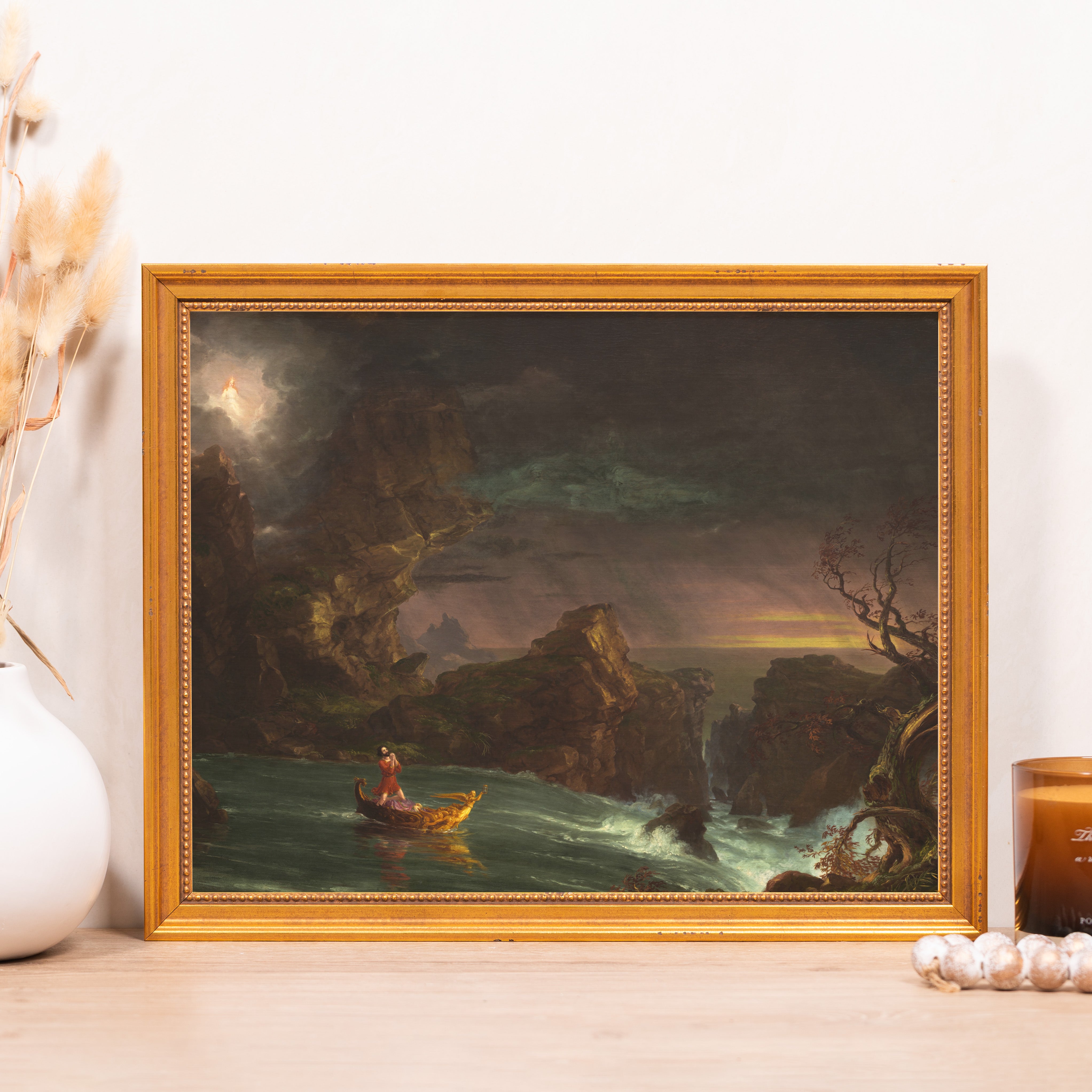 Framed art print of oil painting featuring rocky seascape and boat in ornate gold frame.