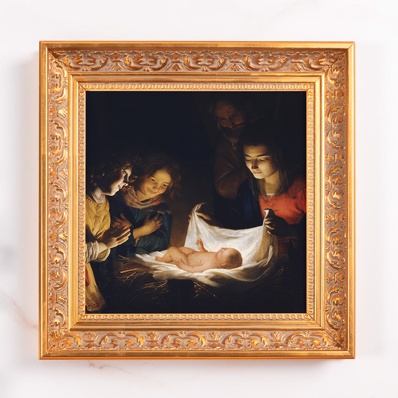 Framed print shows the Nativity scene in an ornate gold frame.