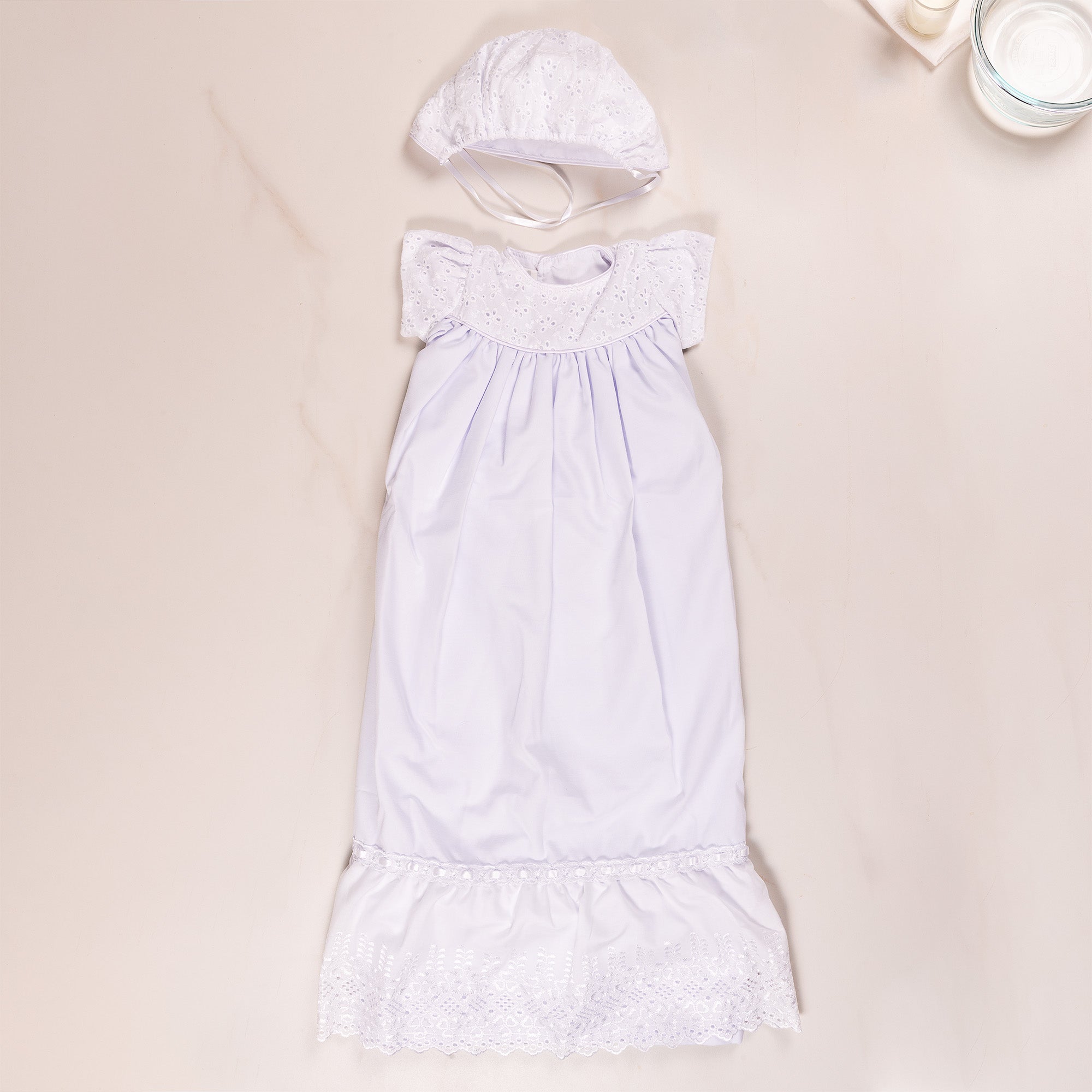 White christening gown with matching bonnet; lace trim.