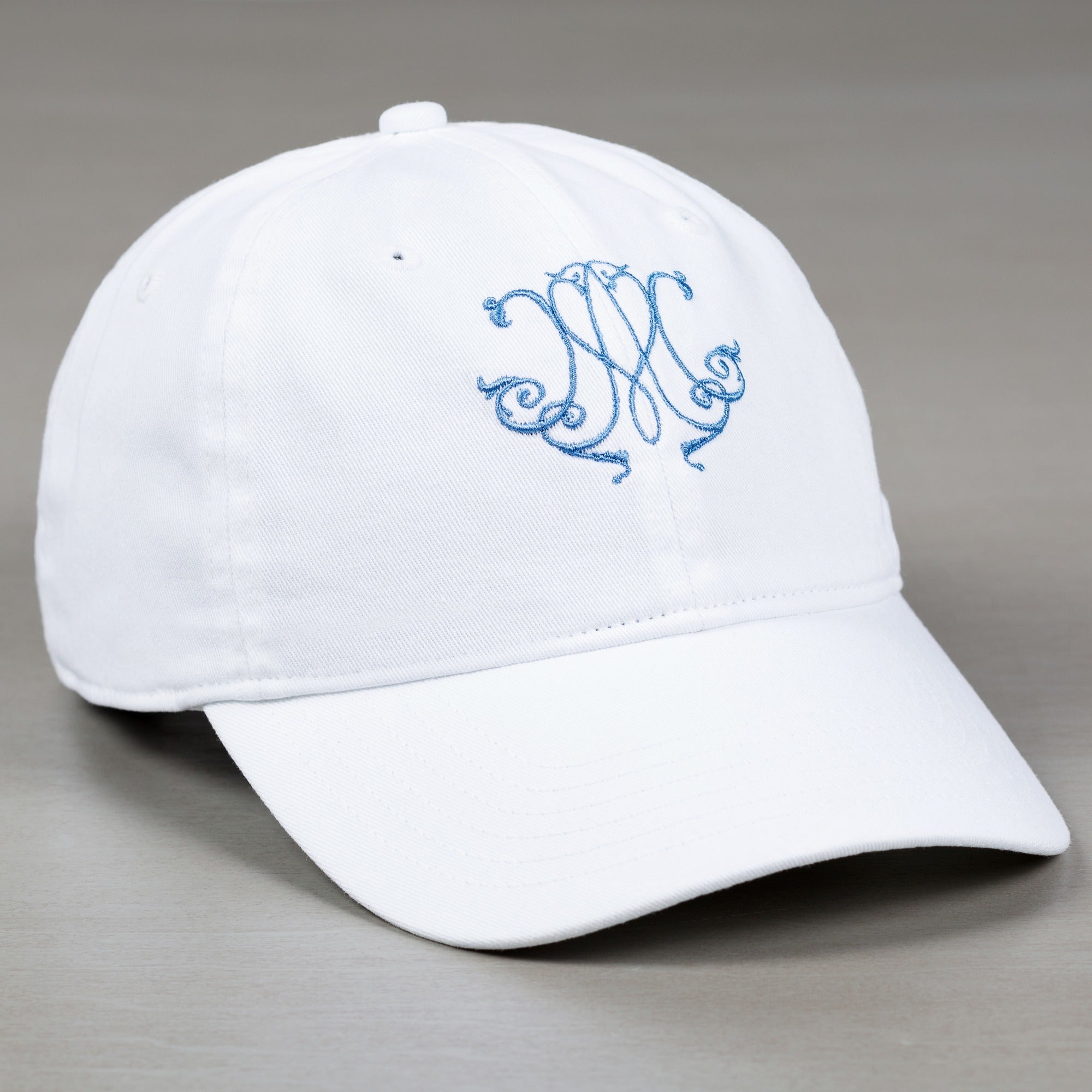 White, Cotton ball cap with embroidered, blue monogram.