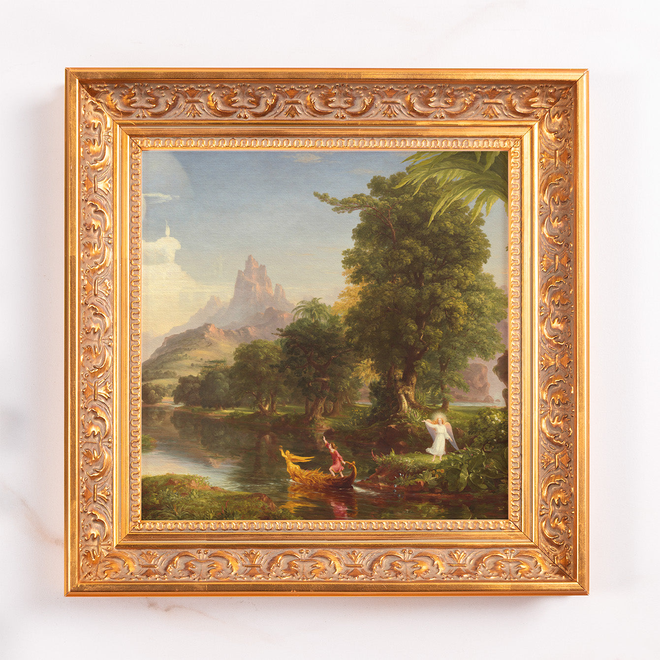 Framed landscape art: Oil painting in ornate gold frame depicting a river scene with mountains and figures.