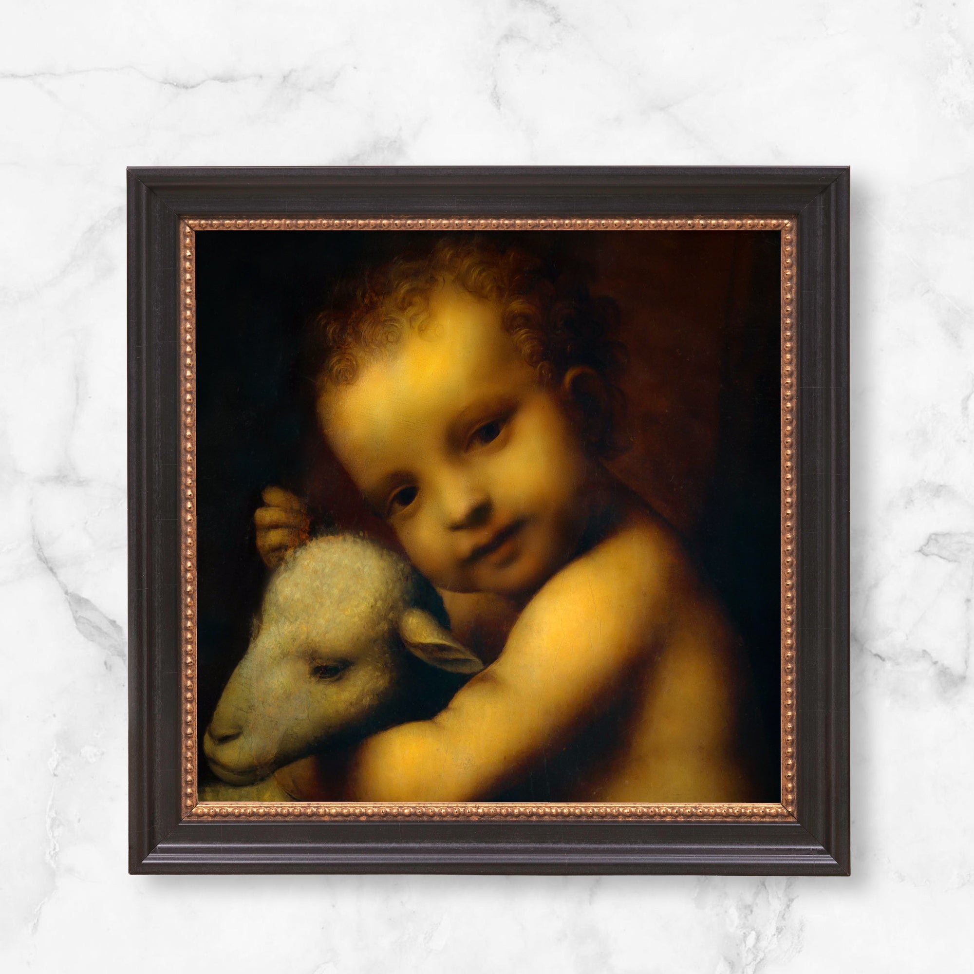 Framed Renaissance art print depicting Christ child with a lamb, dark wood frame.