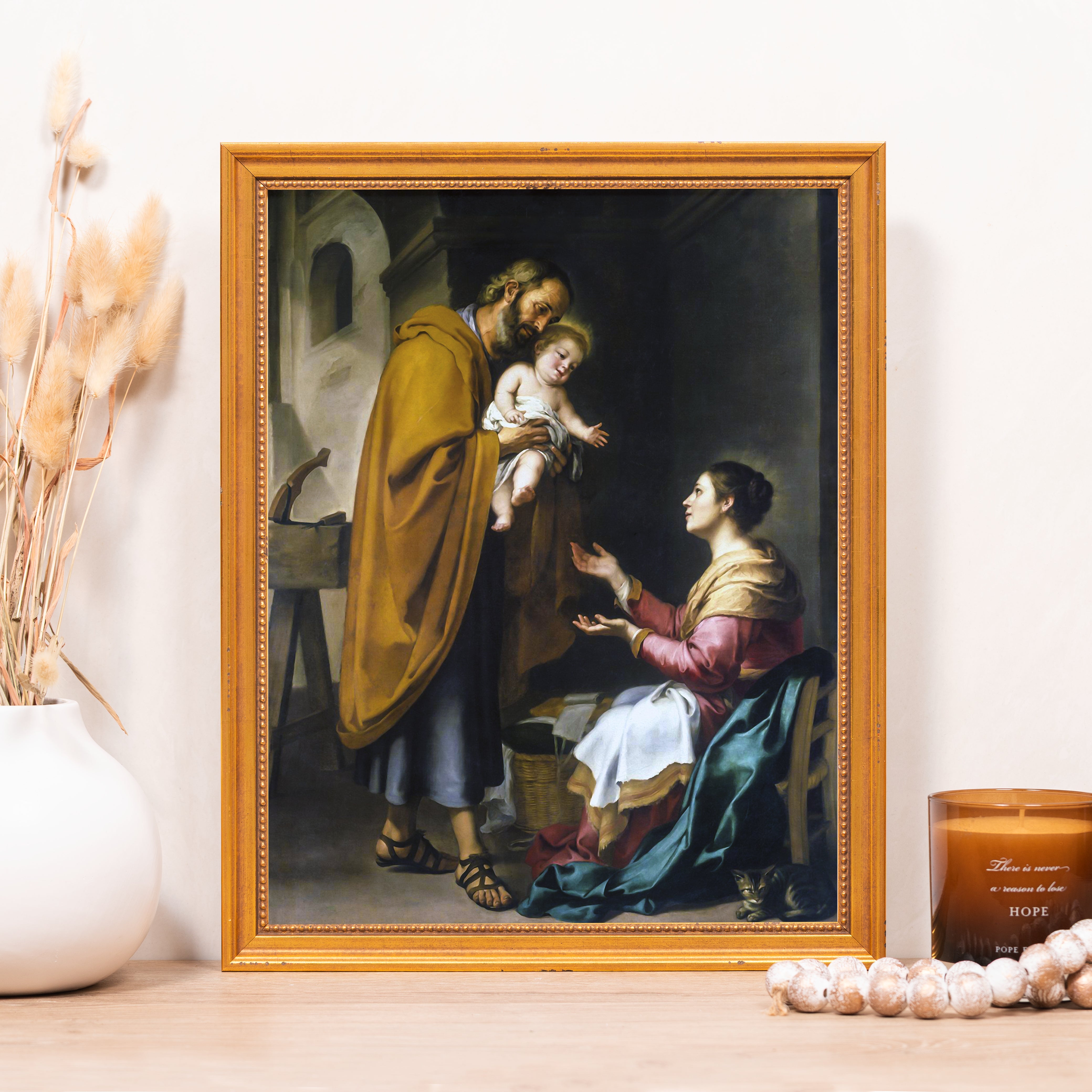 Framed print depicts the Holy Family with Joseph, Jesus, and Mary in an old-master painting style.